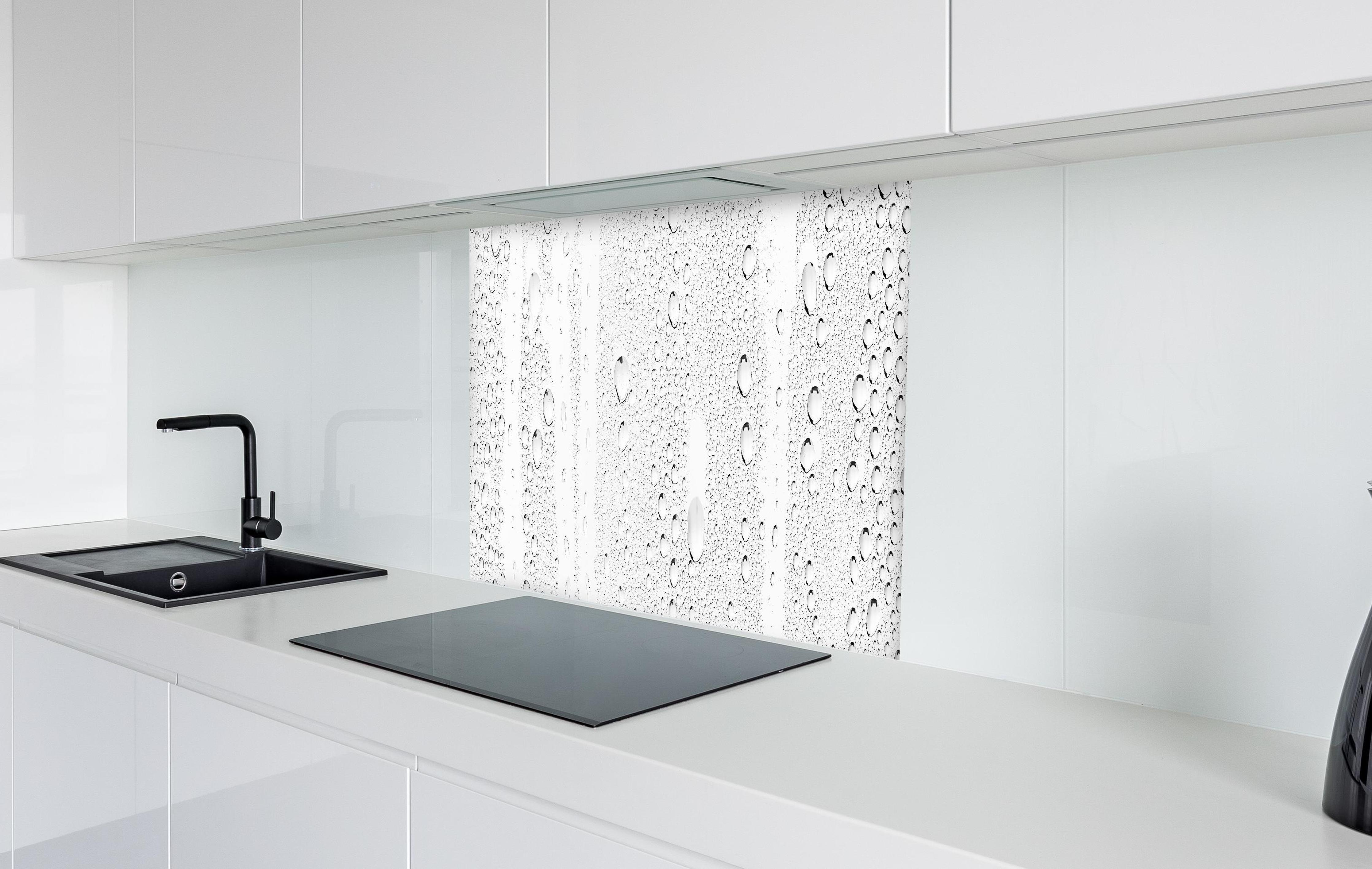 Spritzschutz - Wassertropfen auf Glas in weißer Hochglanz-Küche hinter einem Cerankochfeld