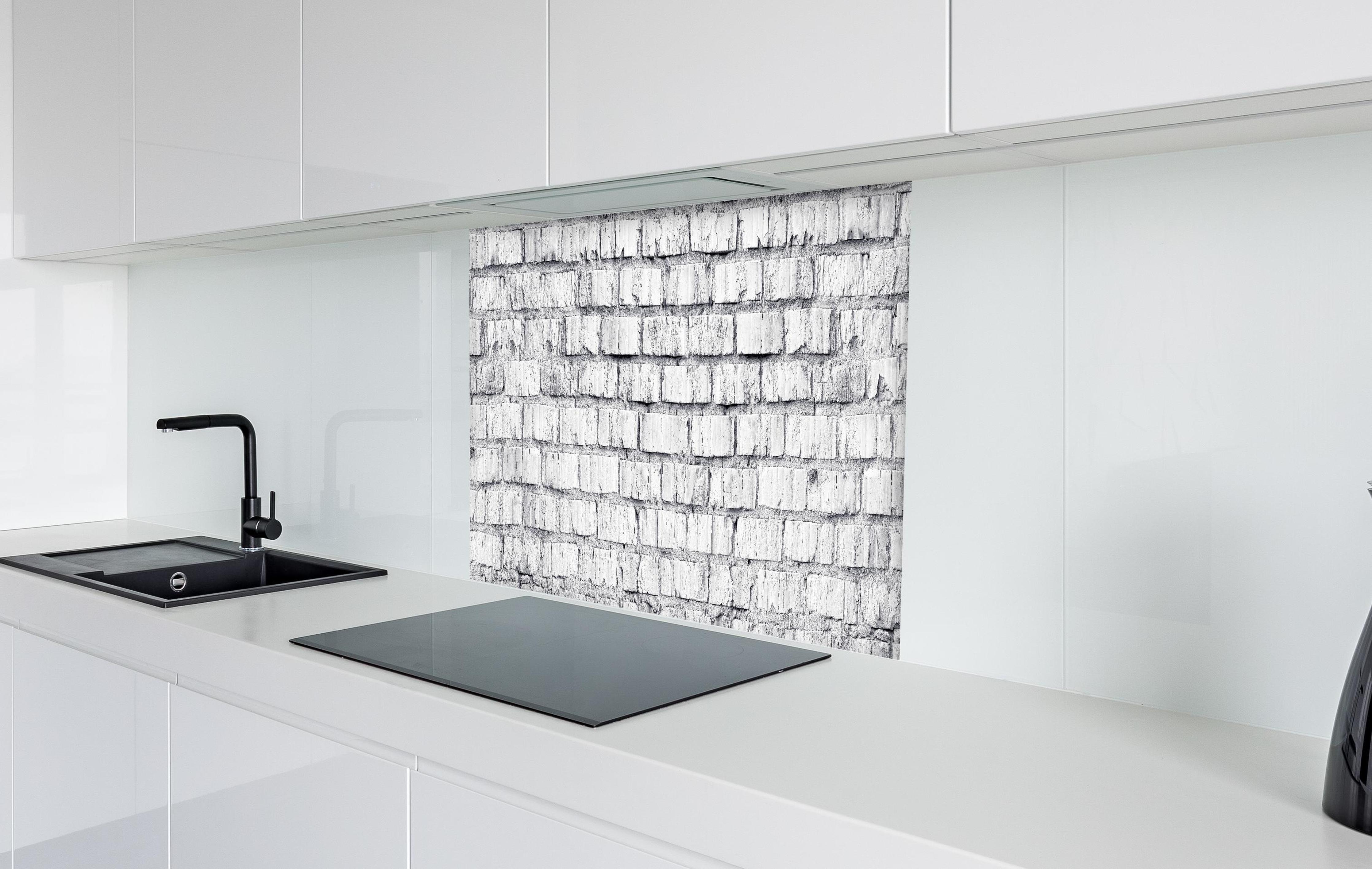 Spritzschutz - Weiß gekalkte Ziegelmauer in weißer Hochglanz-Küche hinter einem Cerankochfeld