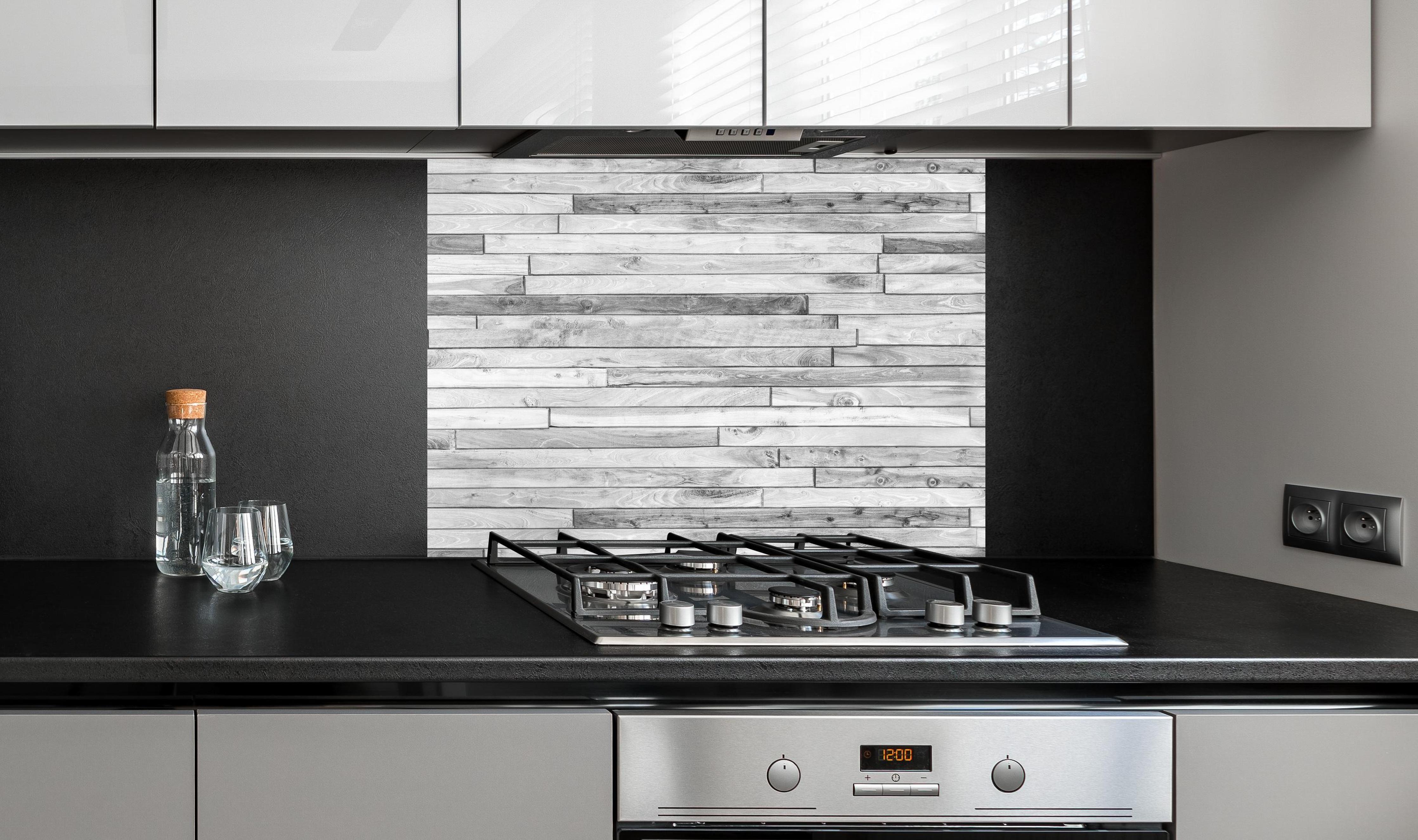 Spritzschutz - Weiße kleine Kiefernholzstücke an edler Anthrazit-Wand hinter silbernem Gasherd