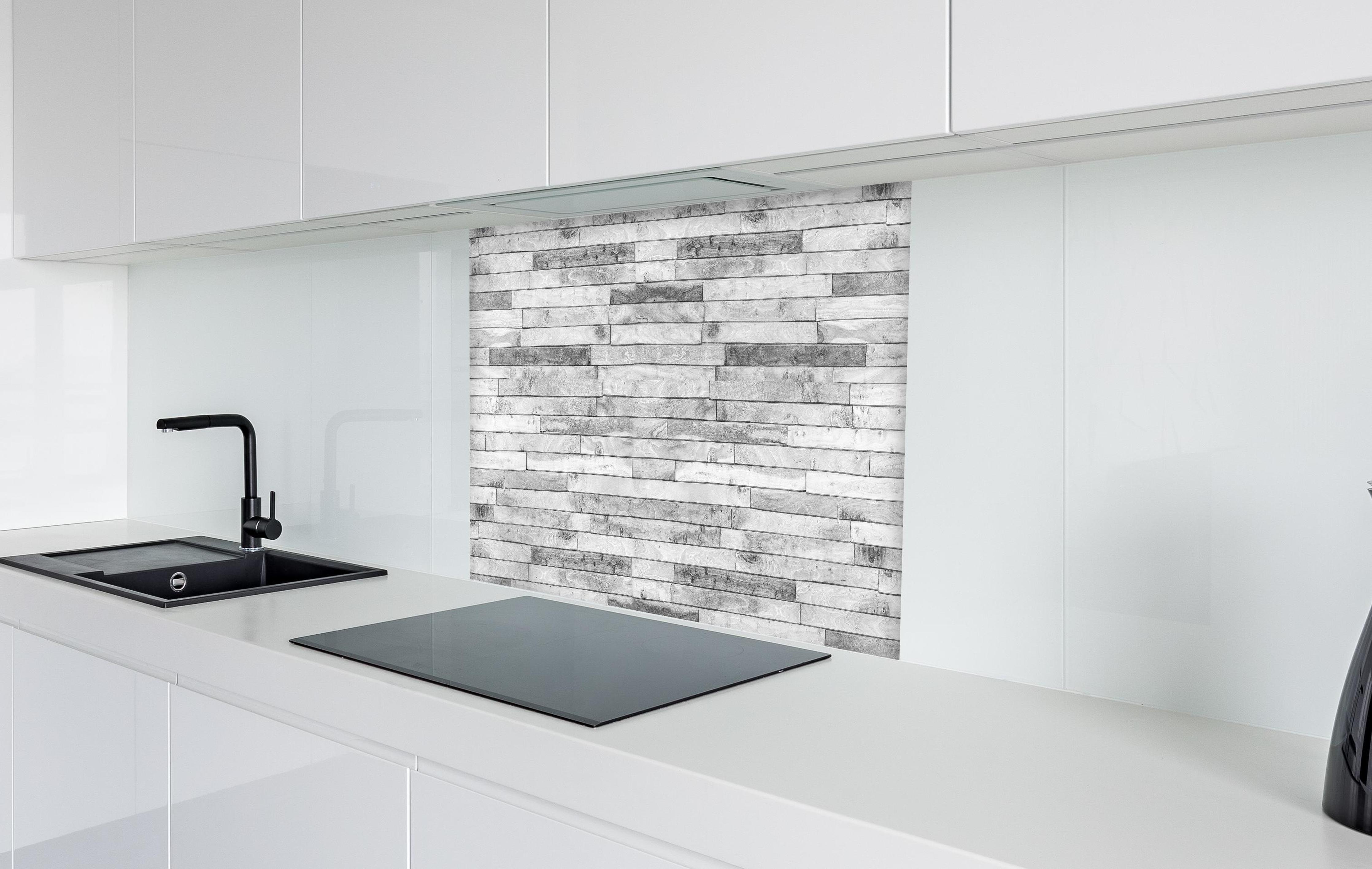 Spritzschutz - Weiße kleine Kiefernholzstücke in weißer Hochglanz-Küche hinter einem Cerankochfeld