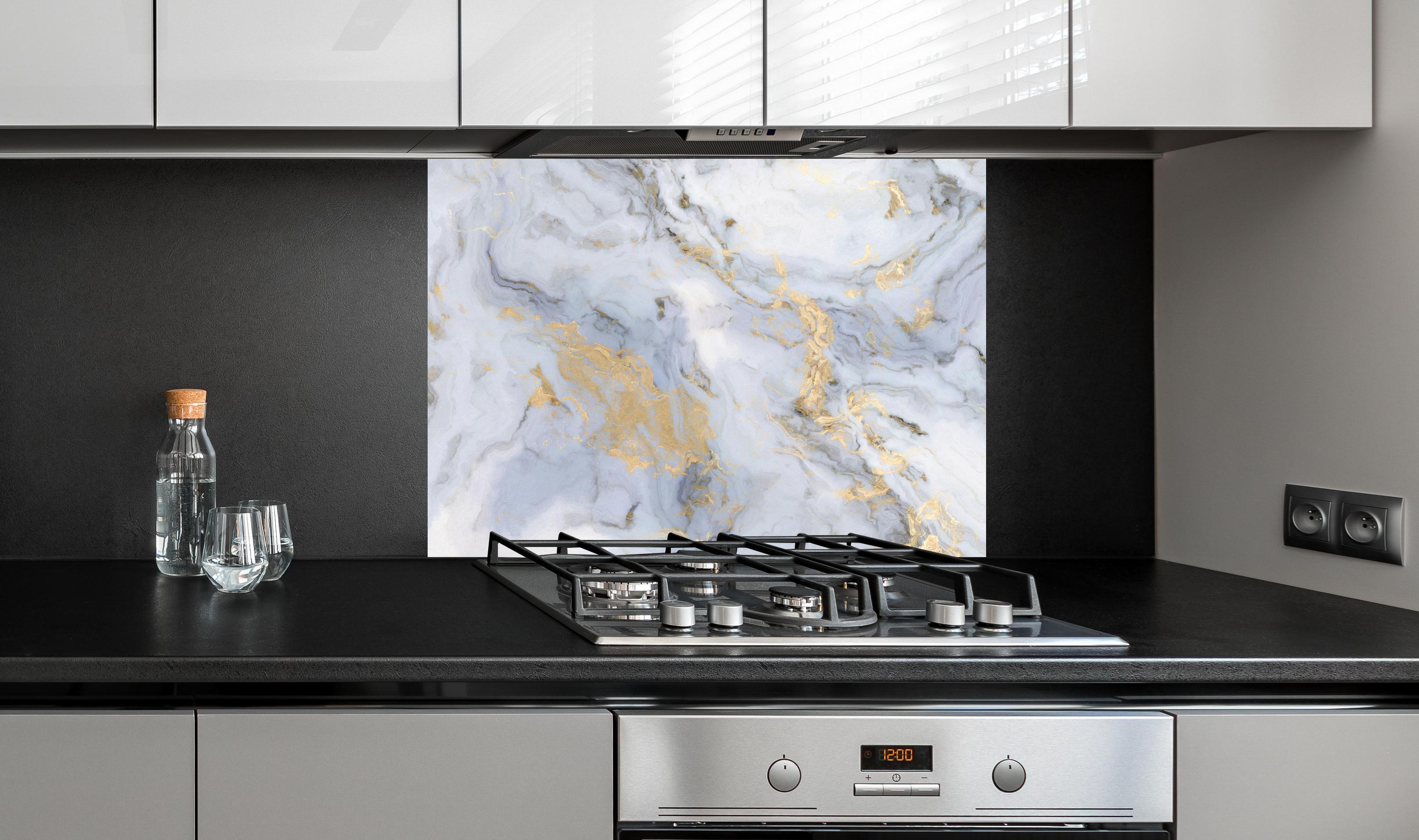 Spritzschutz - Weißer Marmor mit Goldelementen an edler Anthrazit-Wand hinter silbernem Gasherd