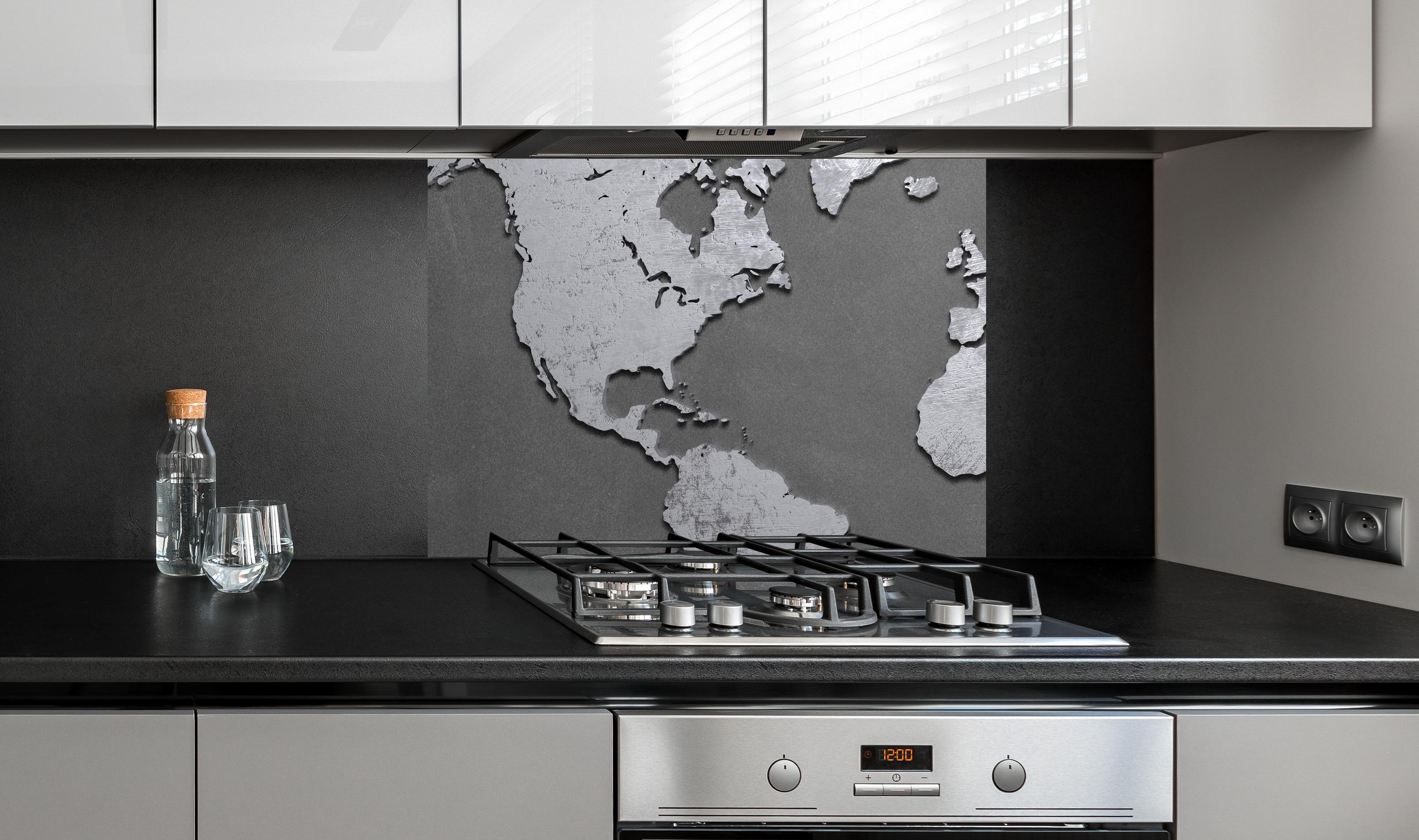 Spritzschutz - Weltkarte aus Metall an edler Anthrazit-Wand hinter silbernem Gasherd