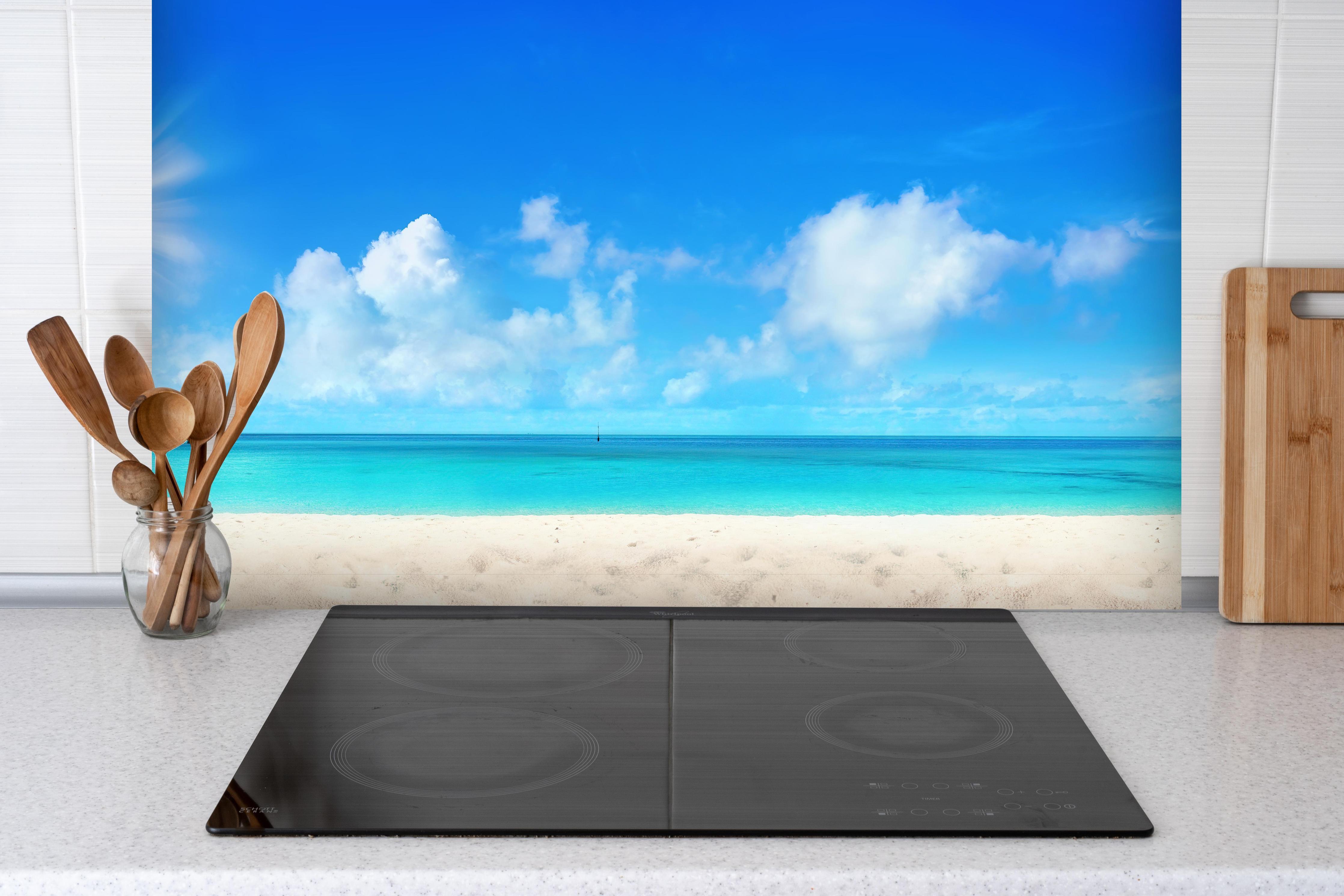 Spritzschutz - Wunderschöner Strand mit hellem Sand hinter einem Cerankochfeld zwischen Holz-Kochutensilien