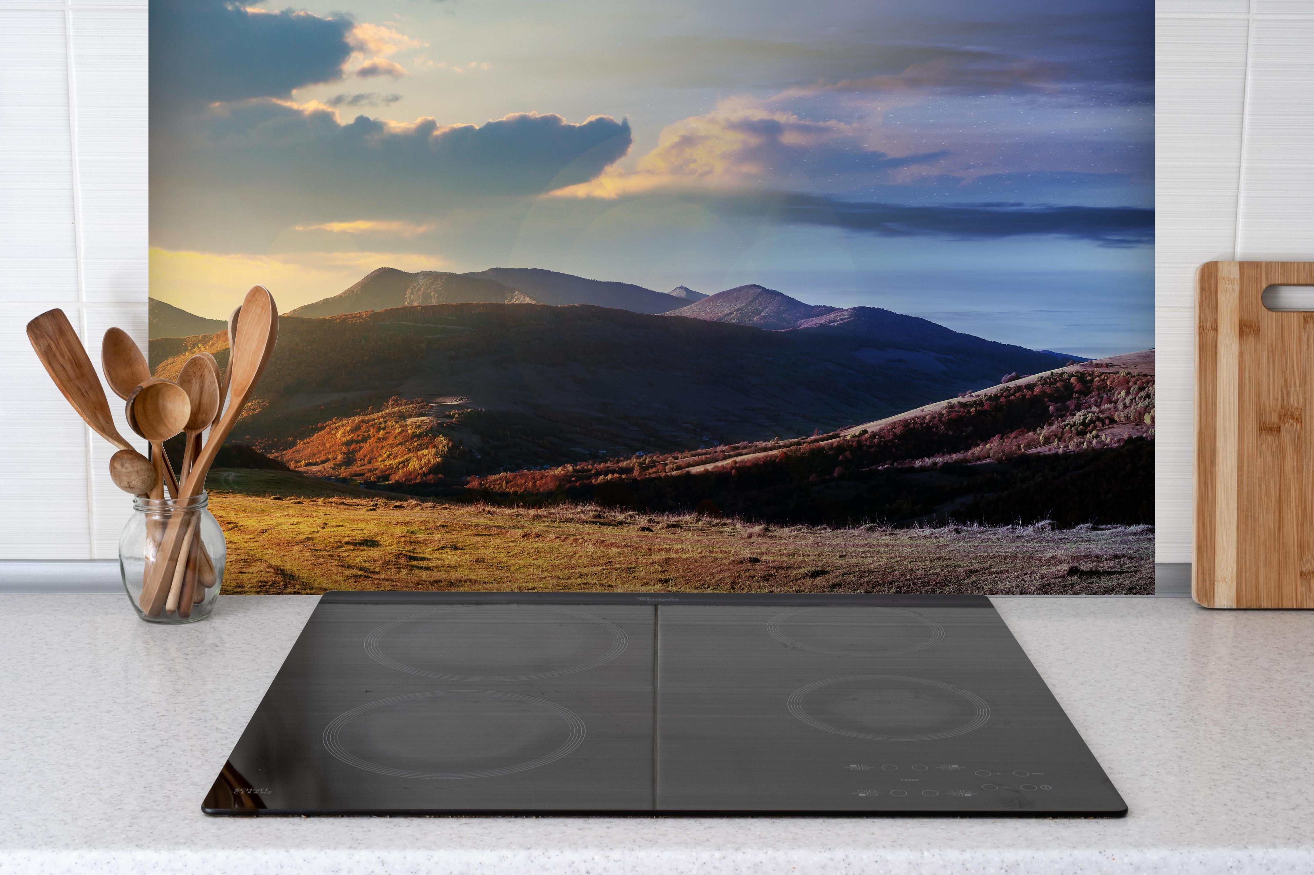 Spritzschutz - Wunderschönes Panorama eines Bergkamms hinter einem Cerankochfeld zwischen Holz-Kochutensilien