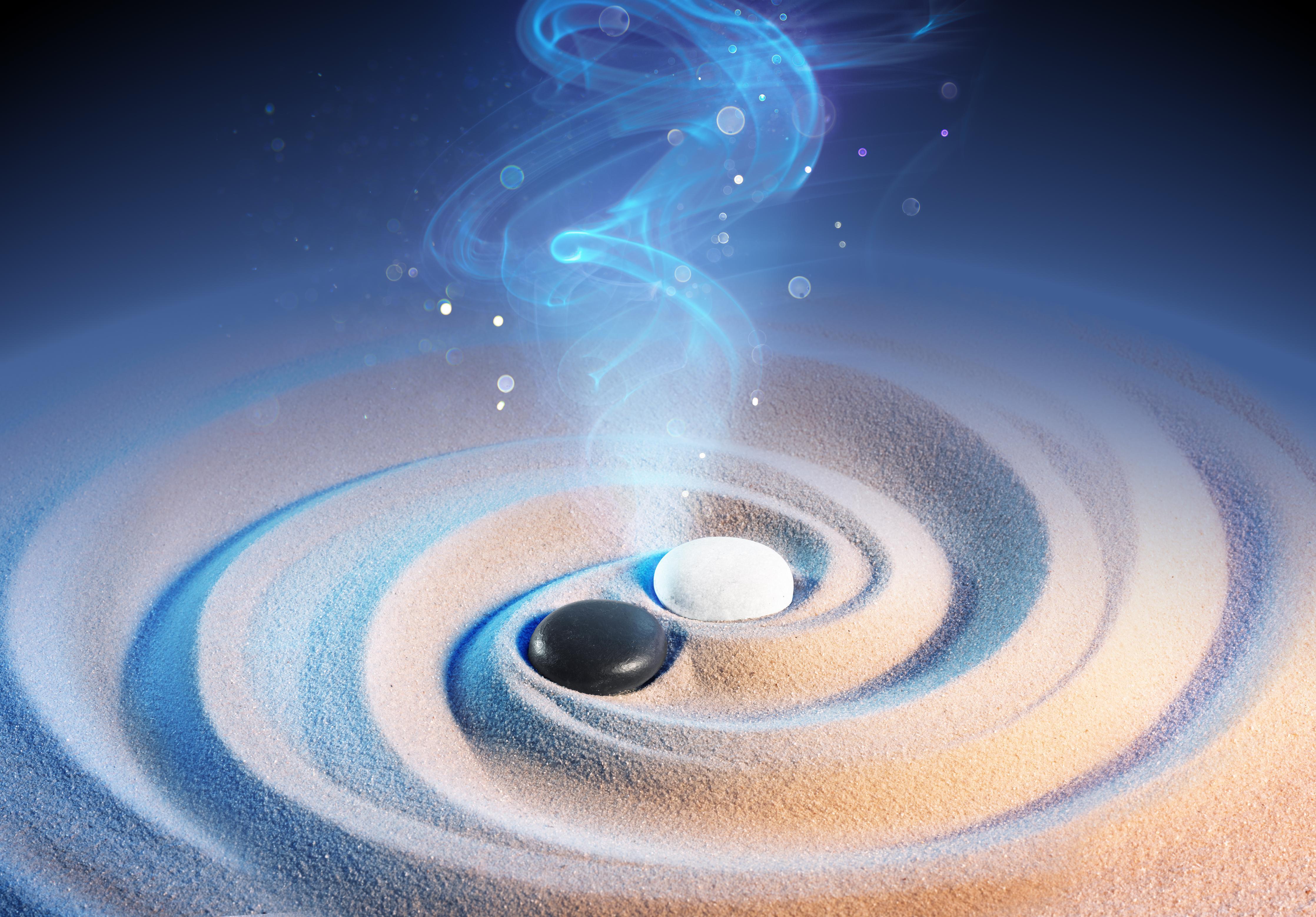 Spritzschutz-Yin und Yang Steine im Sand