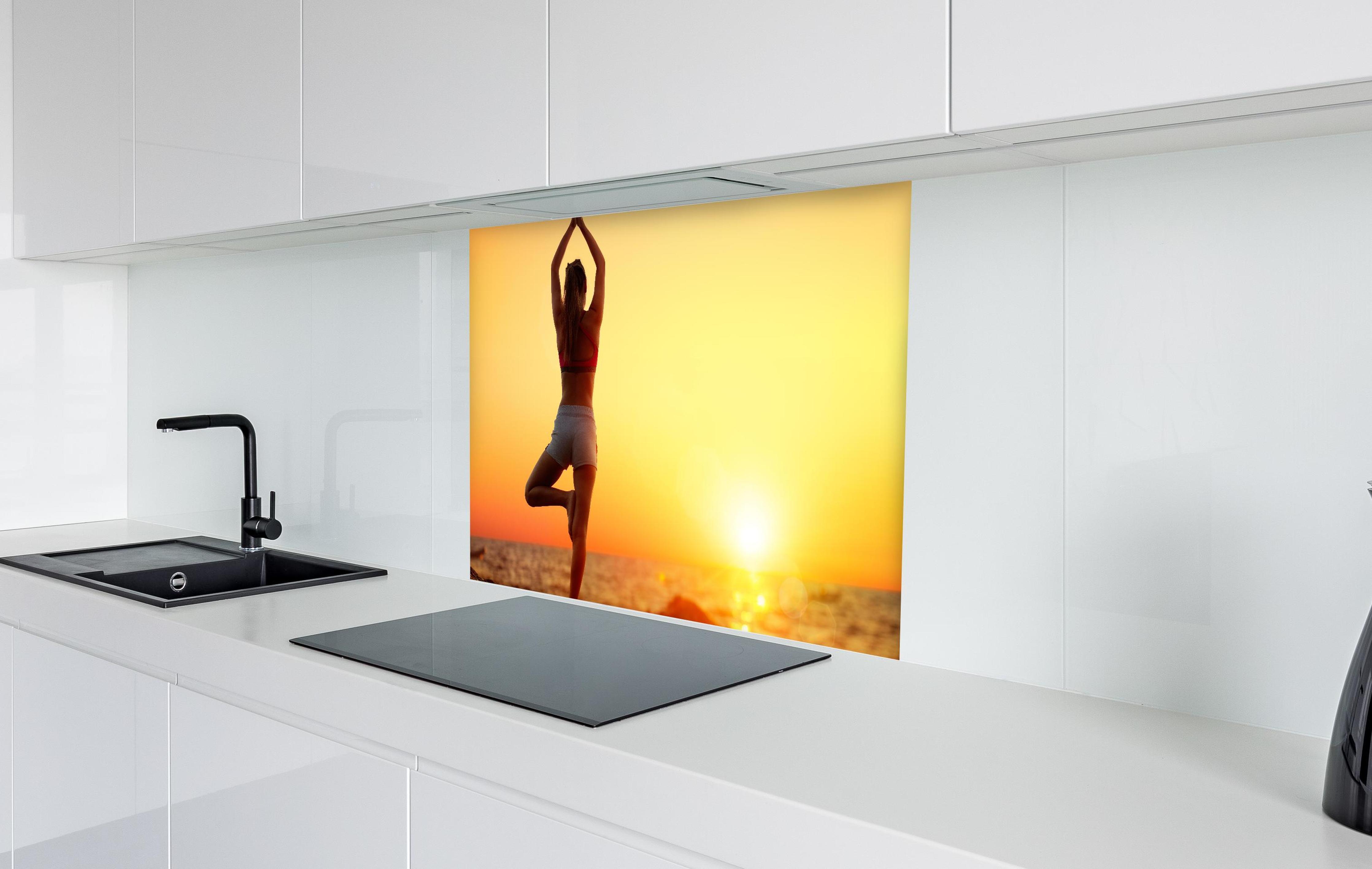 Spritzschutz - Yoga bei Sonnenuntergang in weißer Hochglanz-Küche hinter einem Cerankochfeld