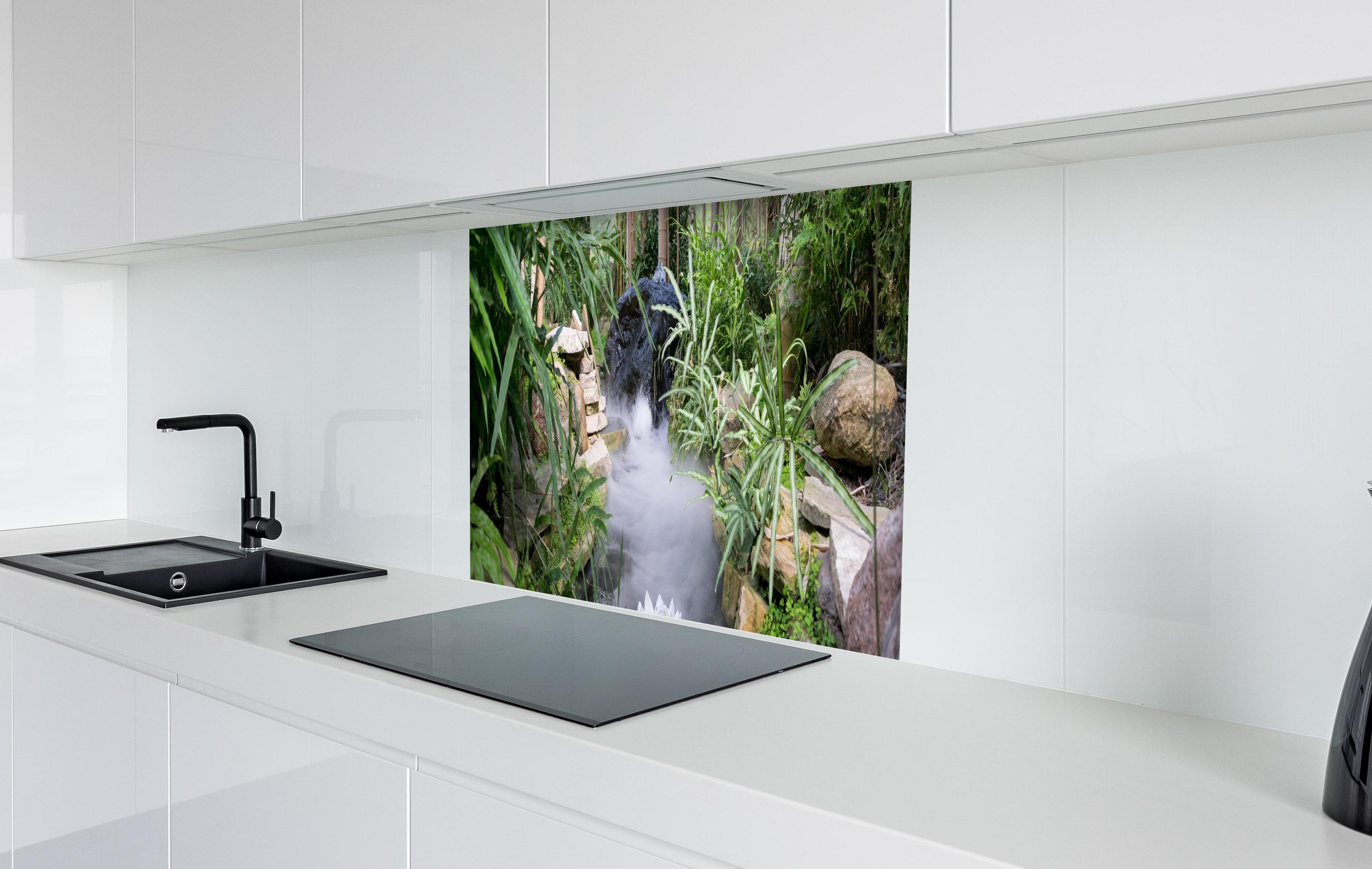 Spritzschutz - Zen-Garten mit weißer Seerose in weißer Hochglanz-Küche hinter einem Cerankochfeld