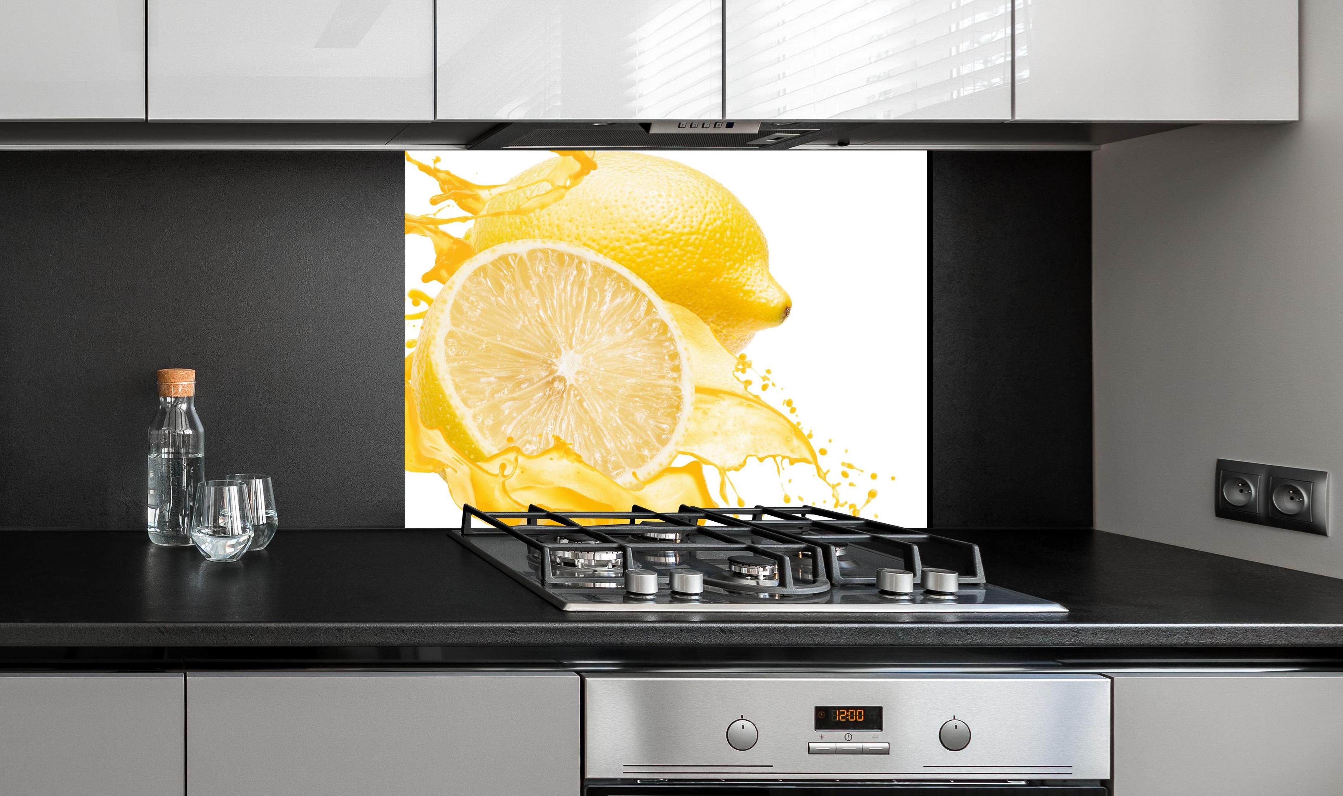 Spritzschutz - Zitronen in gelbem Saft an edler Anthrazit-Wand hinter silbernem Gasherd