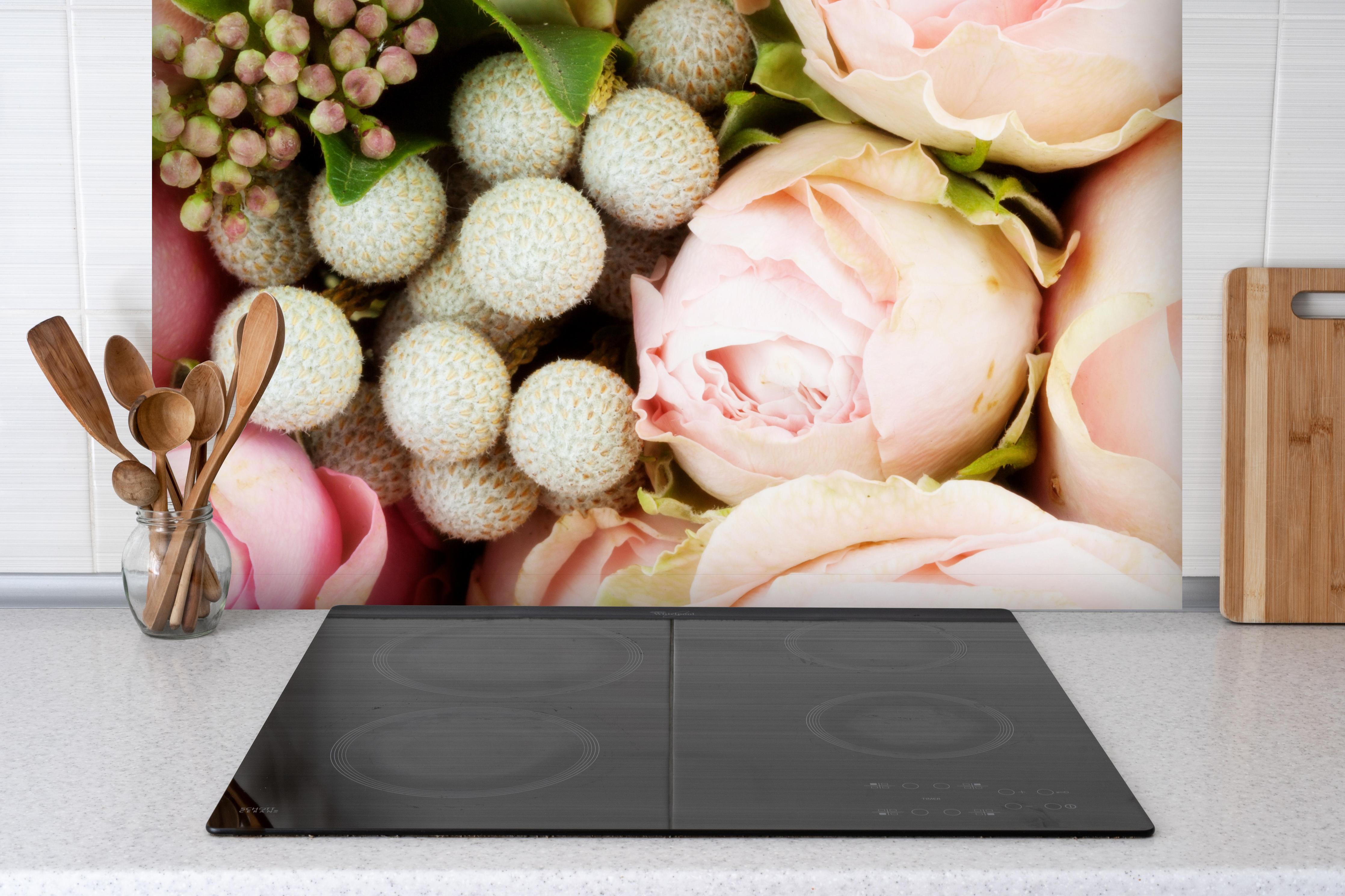 Spritzschutz - bunter sommerlicher Blumenstrauß hinter einem Cerankochfeld zwischen Holz-Kochutensilien