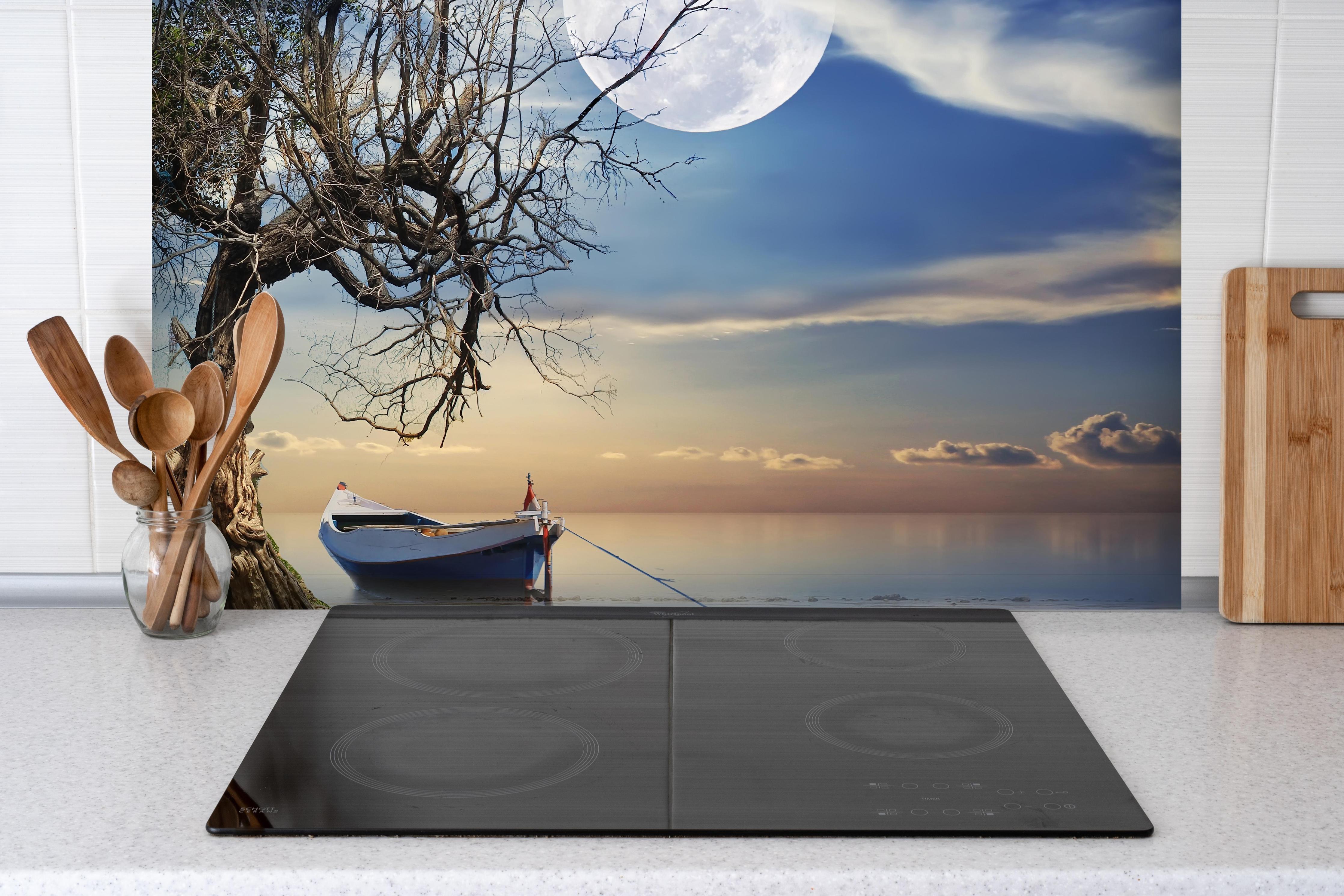 Spritzschutz - einsamer Baum am Strand hinter einem Cerankochfeld zwischen Holz-Kochutensilien