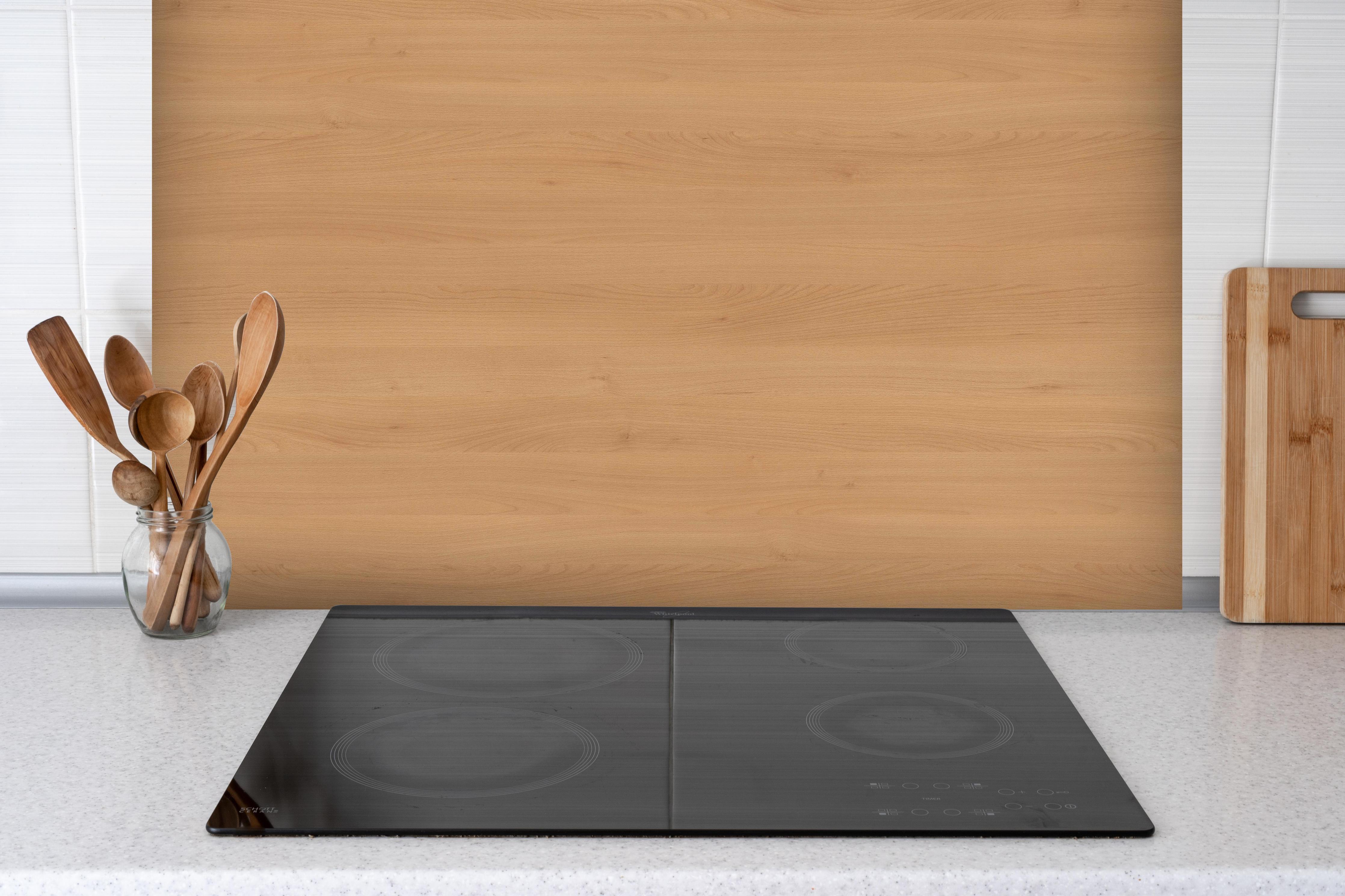 Spritzschutz - harmonisches Natur Holz hinter einem Cerankochfeld zwischen Holz-Kochutensilien