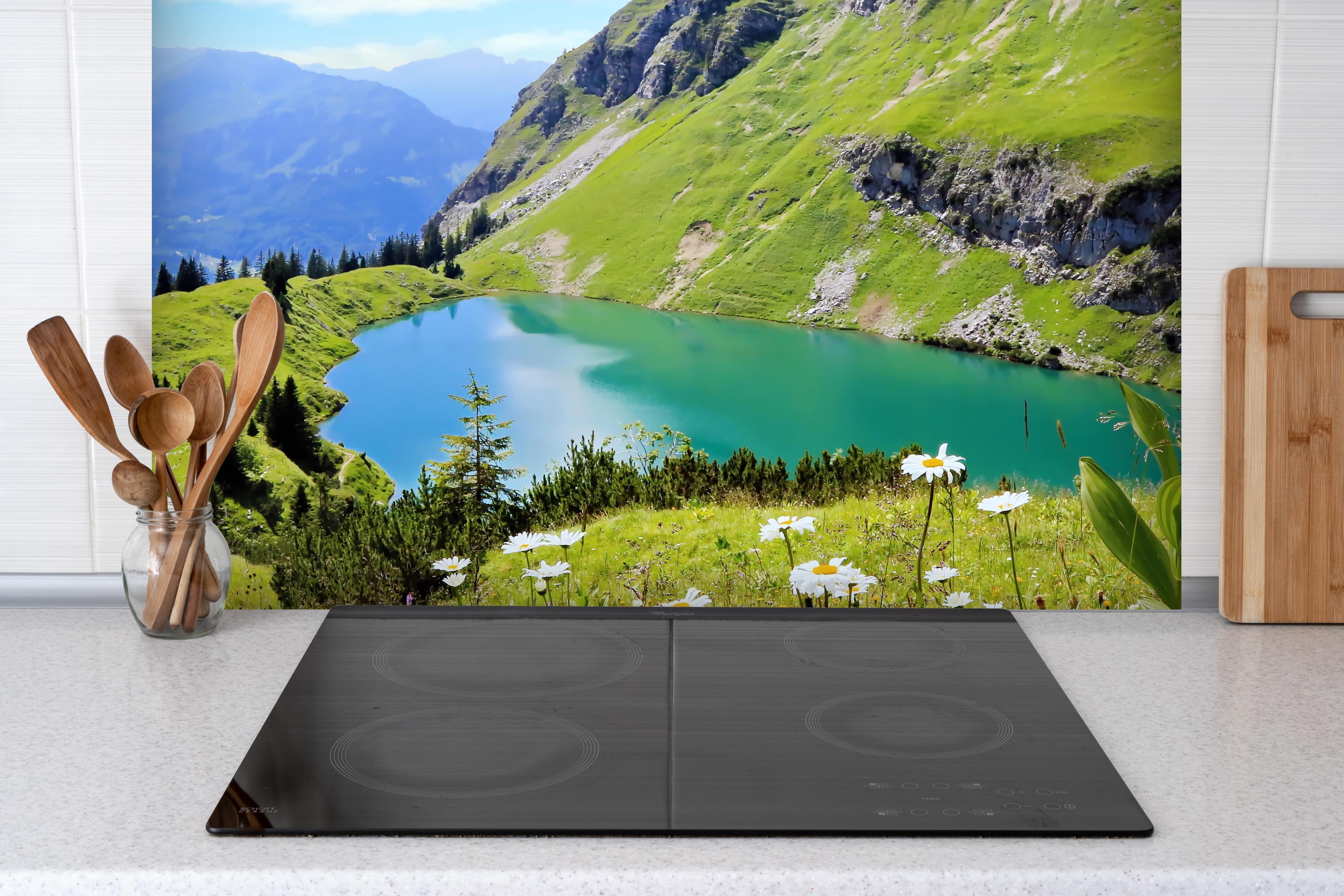 Spritzschutz - idyllischer Seealpsee hinter einem Cerankochfeld zwischen Holz-Kochutensilien