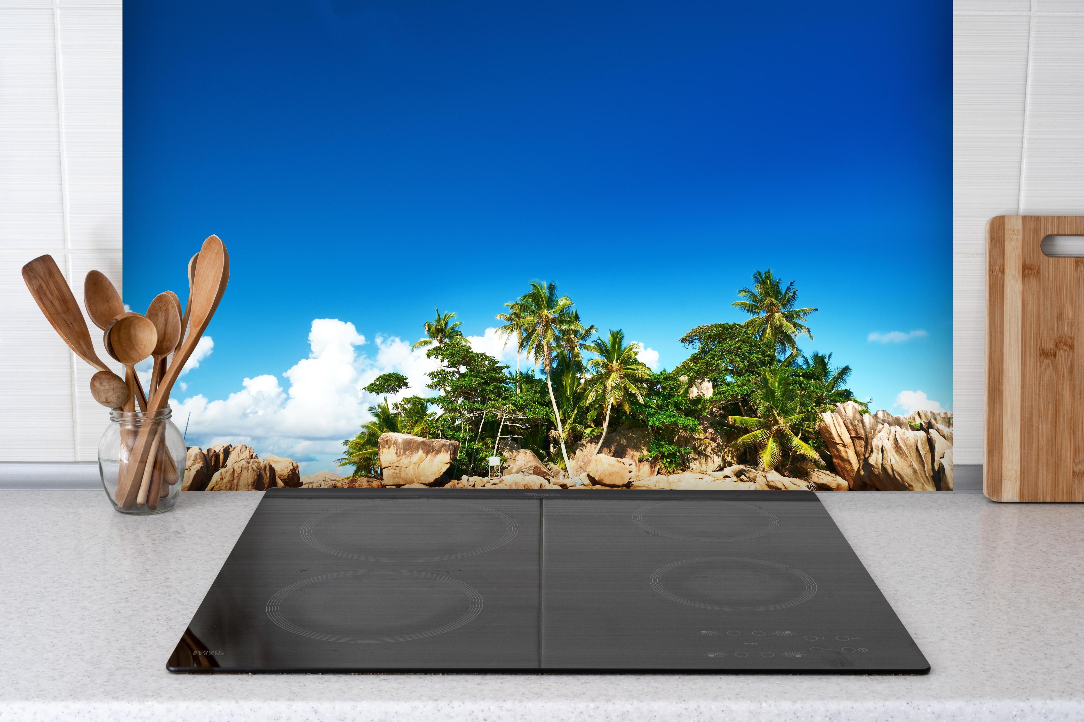 Spritzschutz - kleine tropische Insel vor Sankt Pierre hinter einem Cerankochfeld zwischen Holz-Kochutensilien