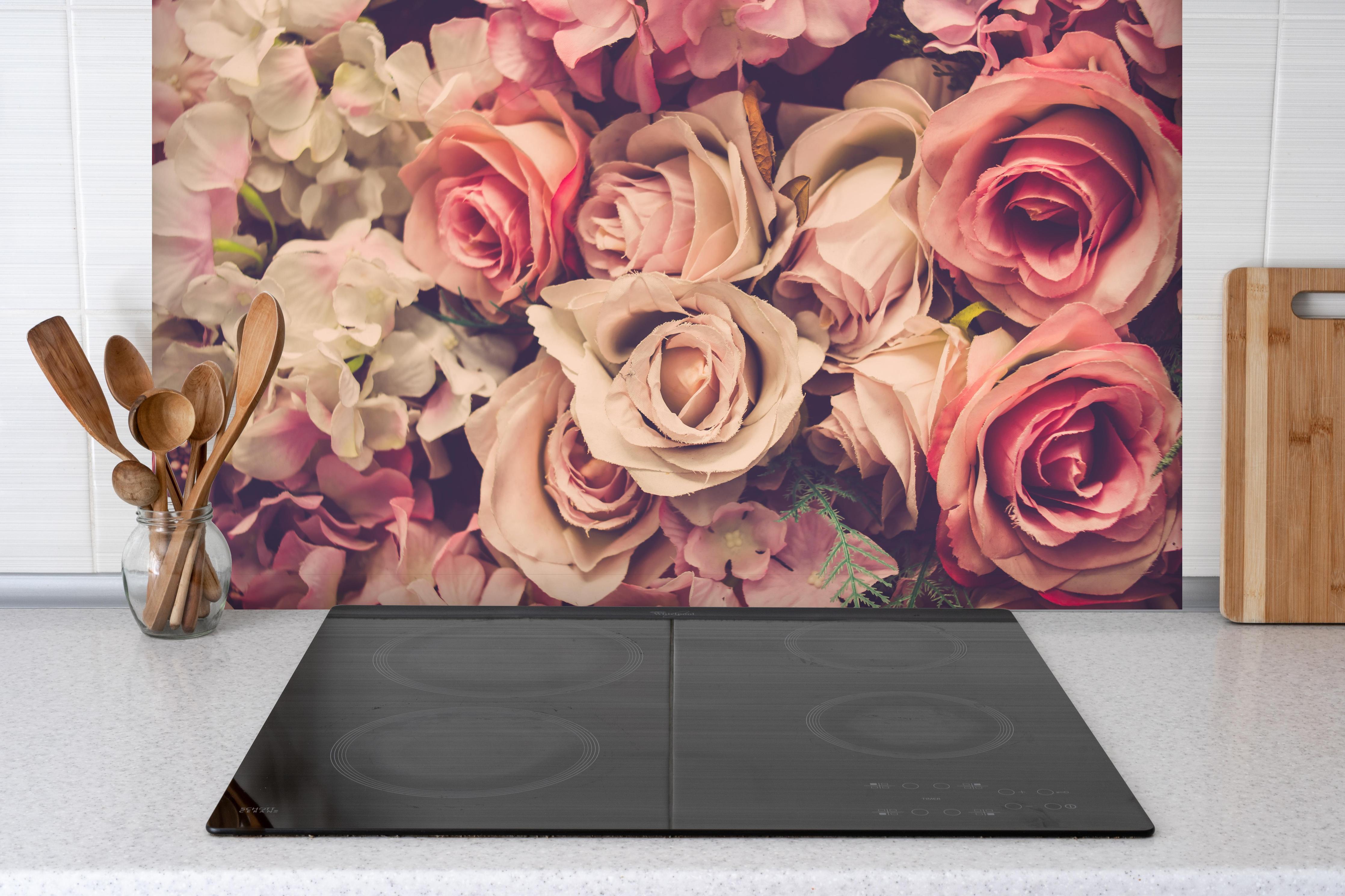 Spritzschutz - retro rosa Rosen hinter einem Cerankochfeld zwischen Holz-Kochutensilien
