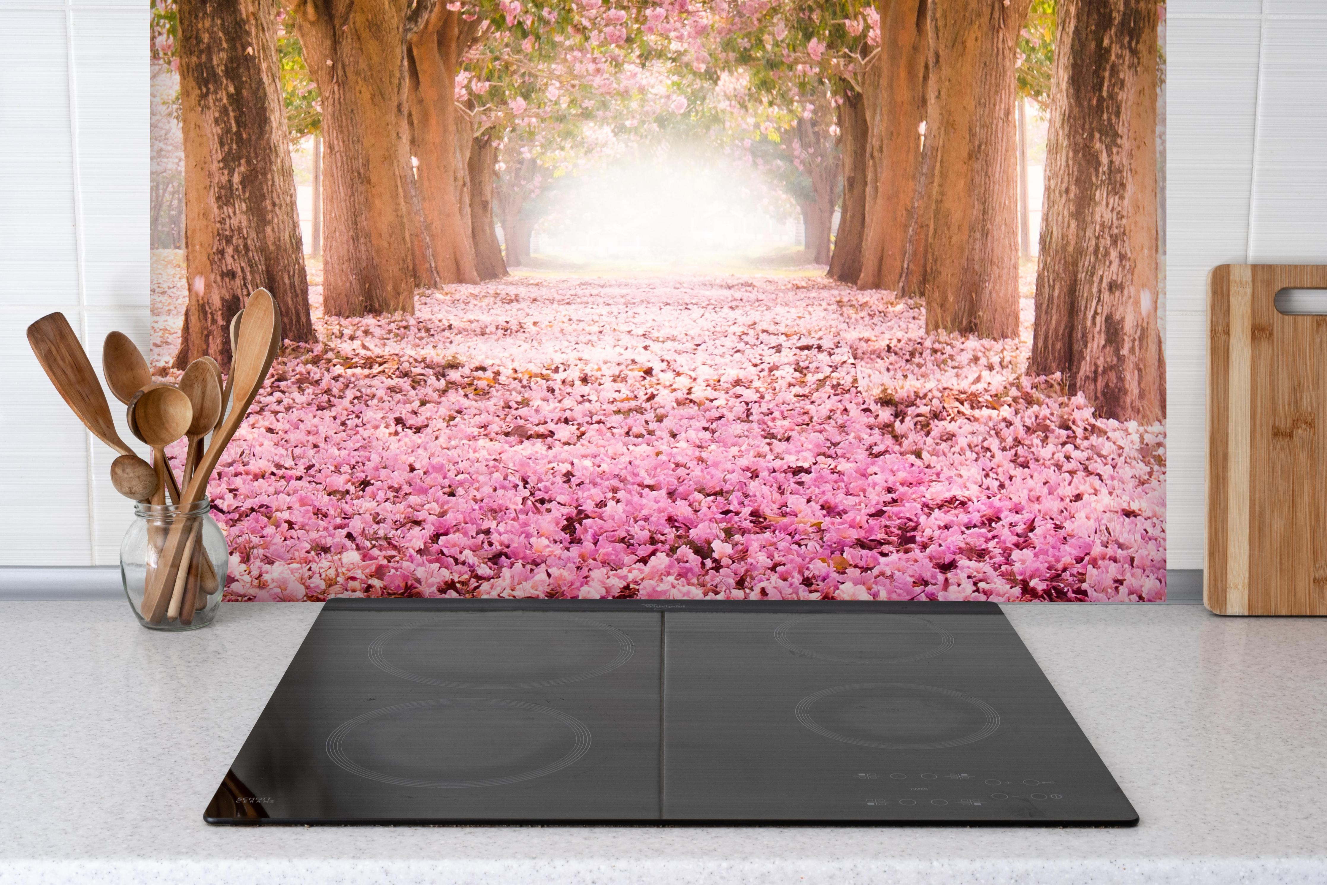 Spritzschutz - romantischer Weg aus Blüten im Wald hinter einem Cerankochfeld zwischen Holz-Kochutensilien