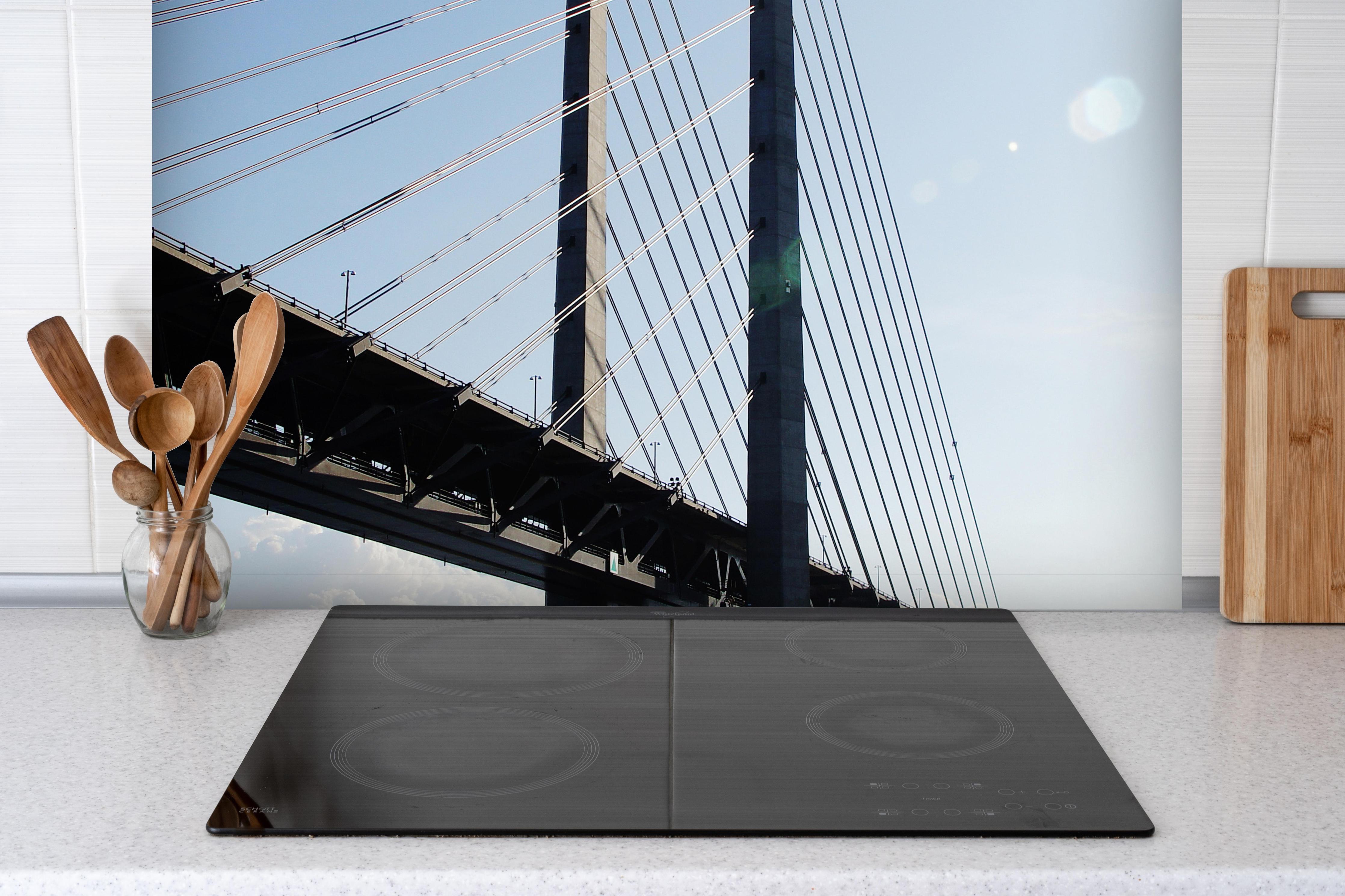 Spritzschutz - spektakuläre Brücke in Schweden hinter einem Cerankochfeld zwischen Holz-Kochutensilien