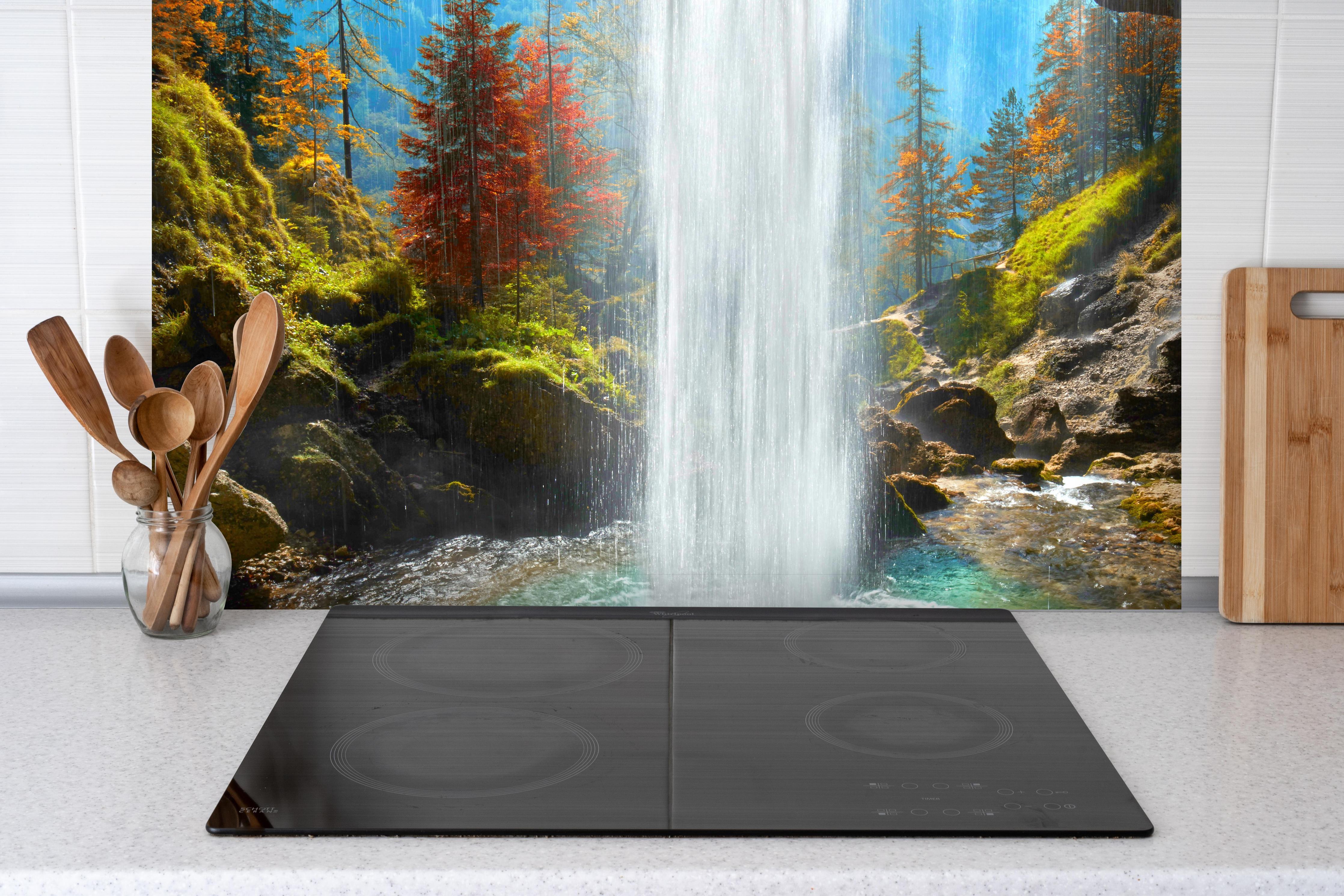 Spritzschutz - türkiser Wasserfall in Slowenien hinter einem Cerankochfeld zwischen Holz-Kochutensilien