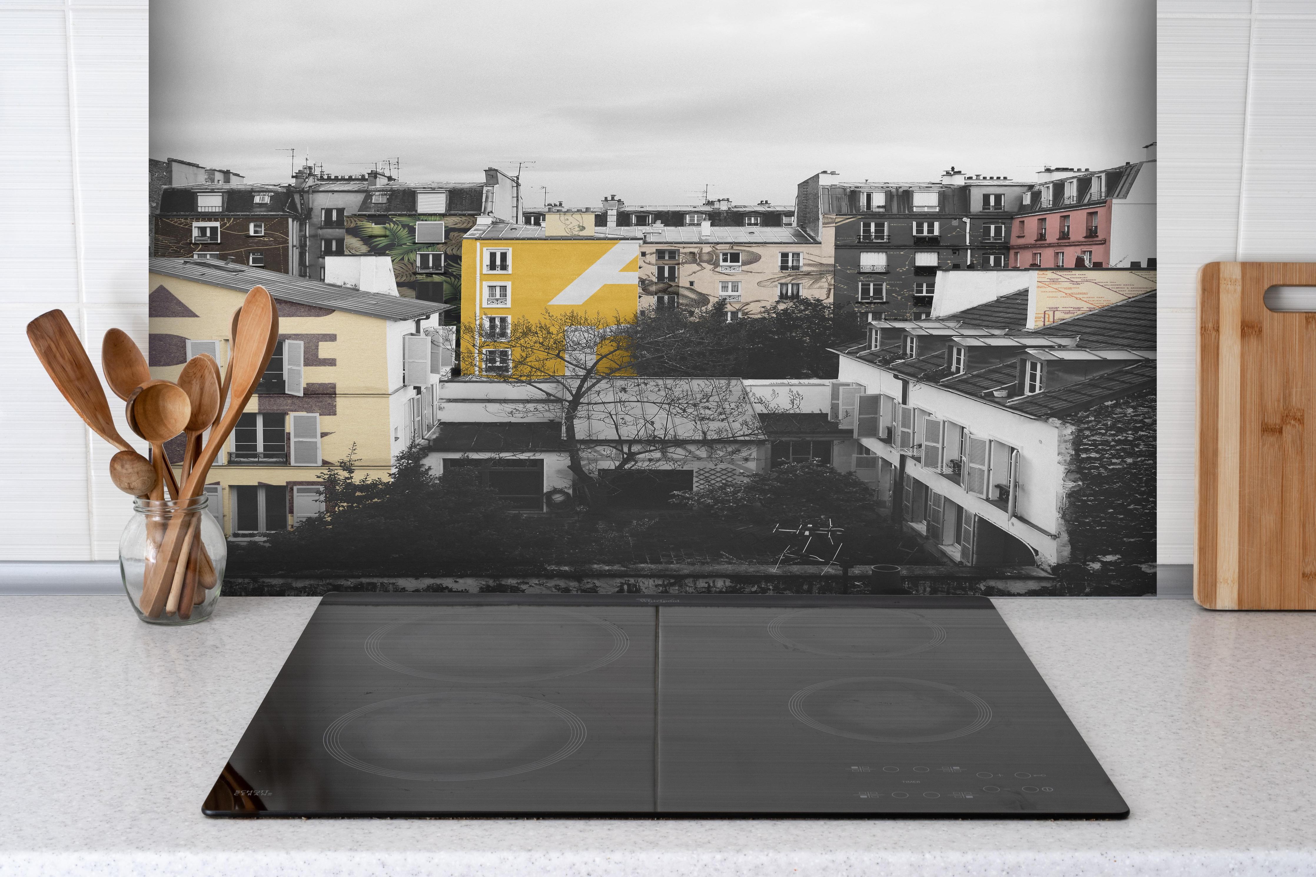 Spritzschutz - Städtische Paris-Szene mit Gelbakzent hinter einem Cerankochfeld zwischen Holz-Kochutensilien