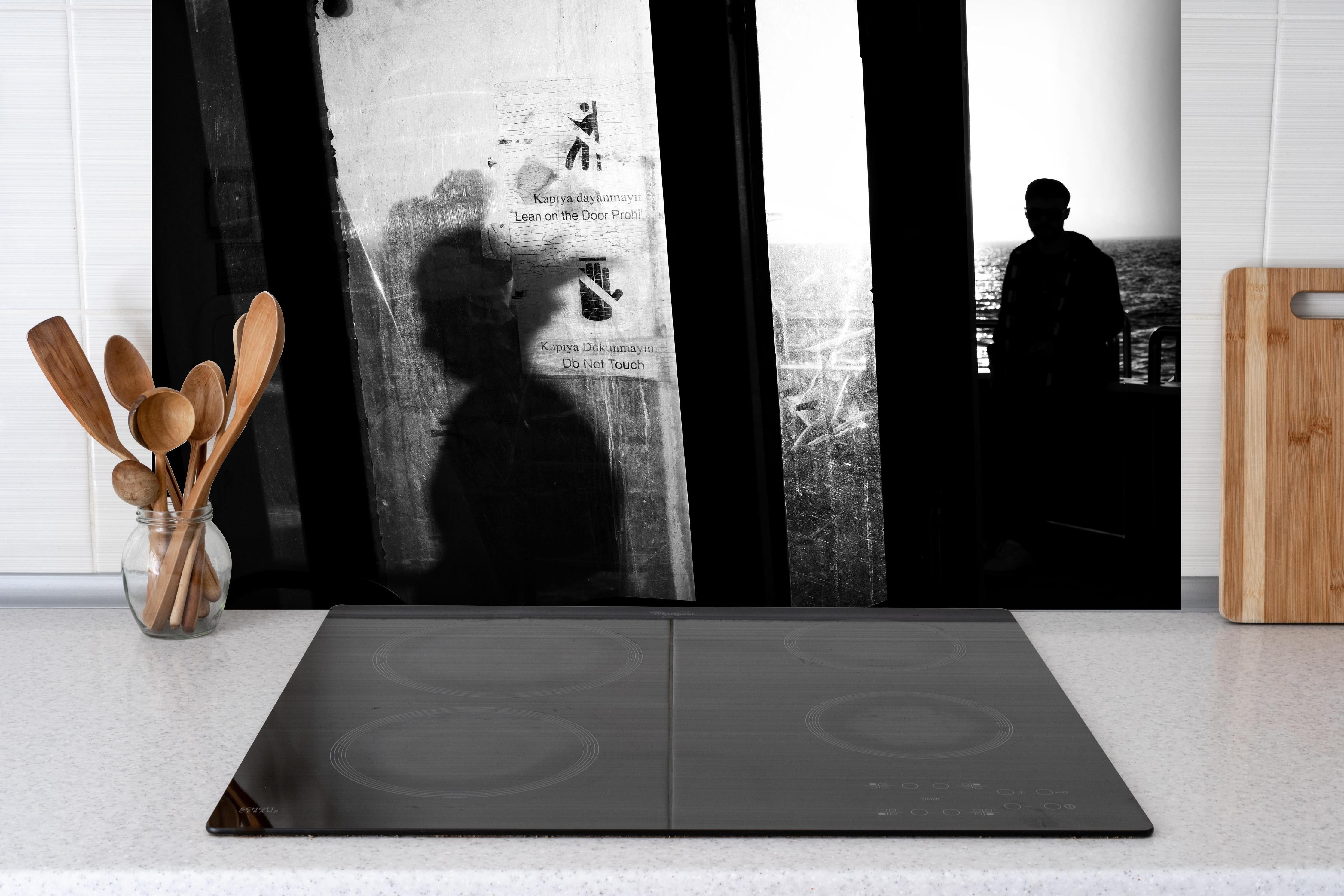 Spritzschutz - Städtisches Bild mit Silhouetten hinter einem Cerankochfeld zwischen Holz-Kochutensilien