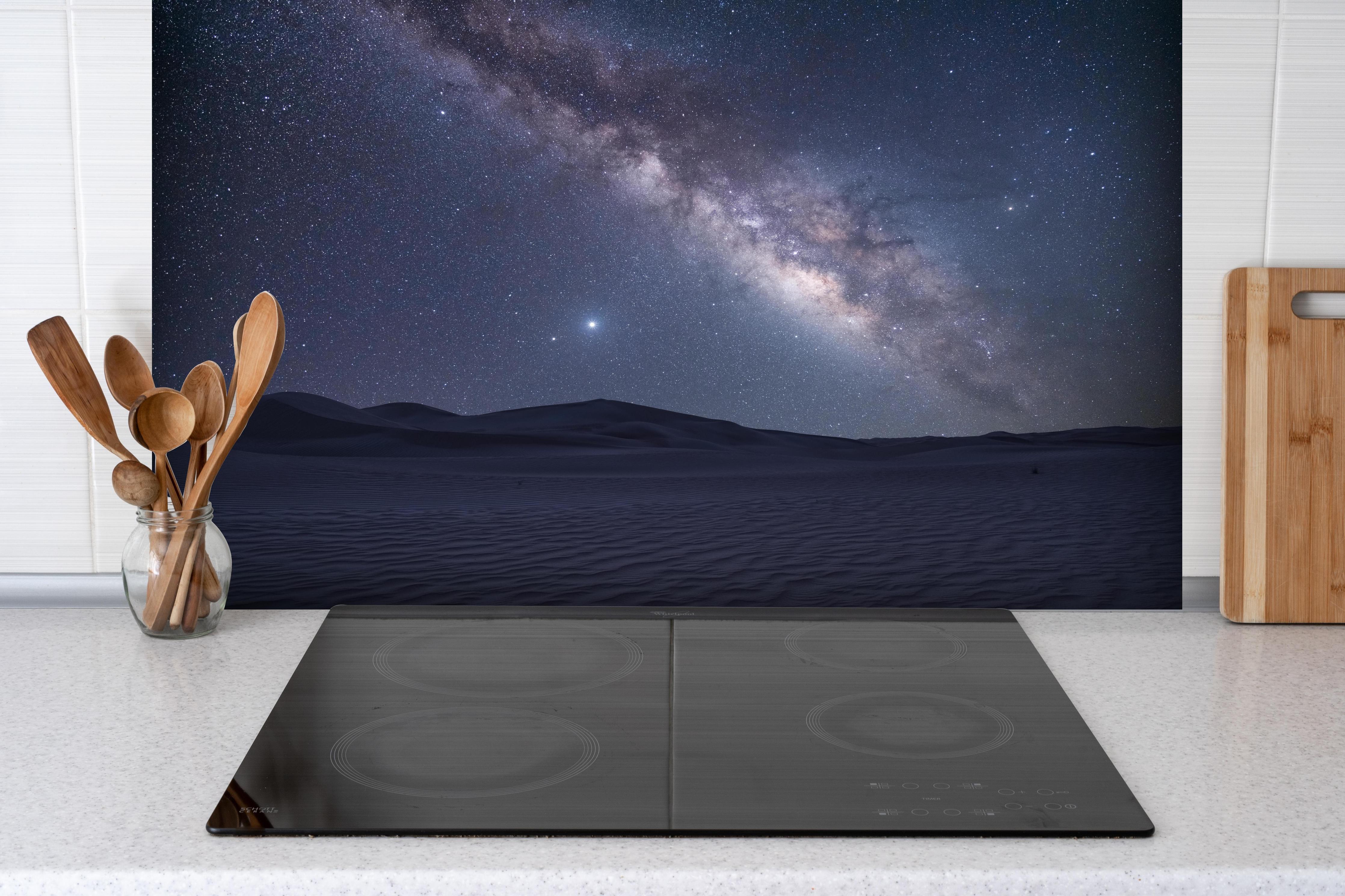 Spritzschutz - Sternenklarer Nachthimmel hinter einem Cerankochfeld zwischen Holz-Kochutensilien