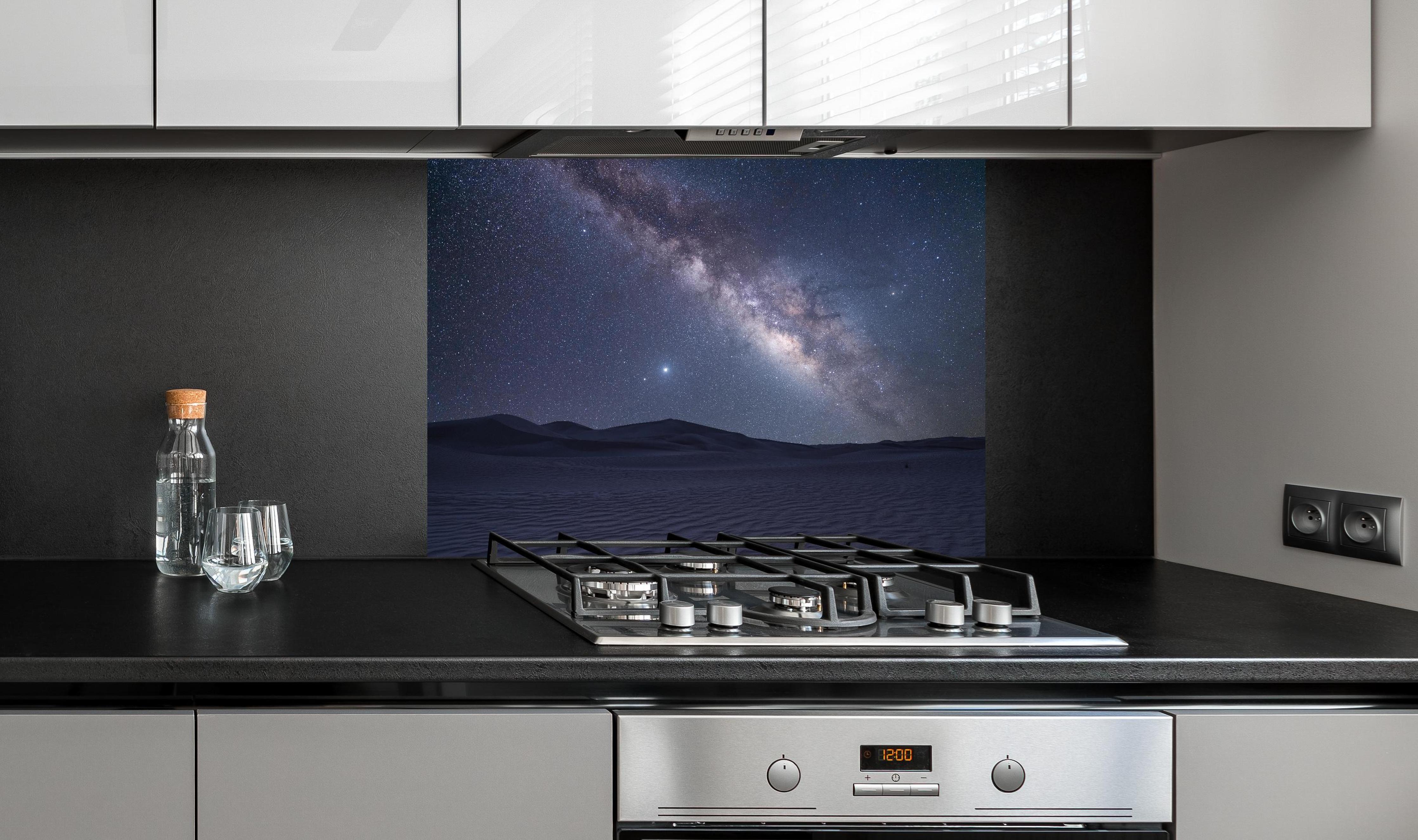 Spritzschutz - Sternenklarer Nachthimmel hinter einem Cerankochfeld zwischen Holz-Kochutensilien