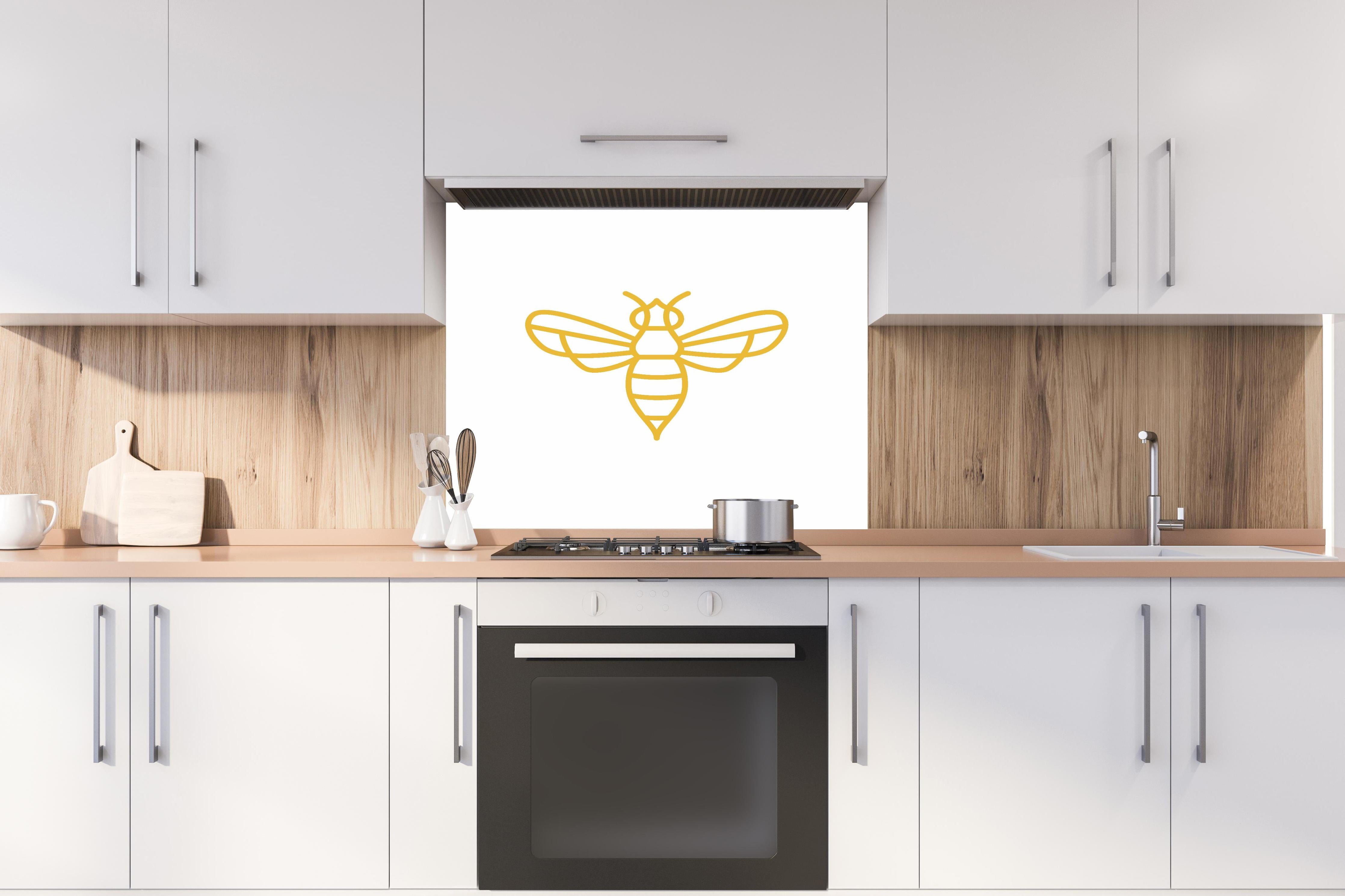 Spritzschutz - Stilisierte Goldfarbene Biene Illustration hinter einem Cerankochfeld zwischen Holz-Kochutensilien