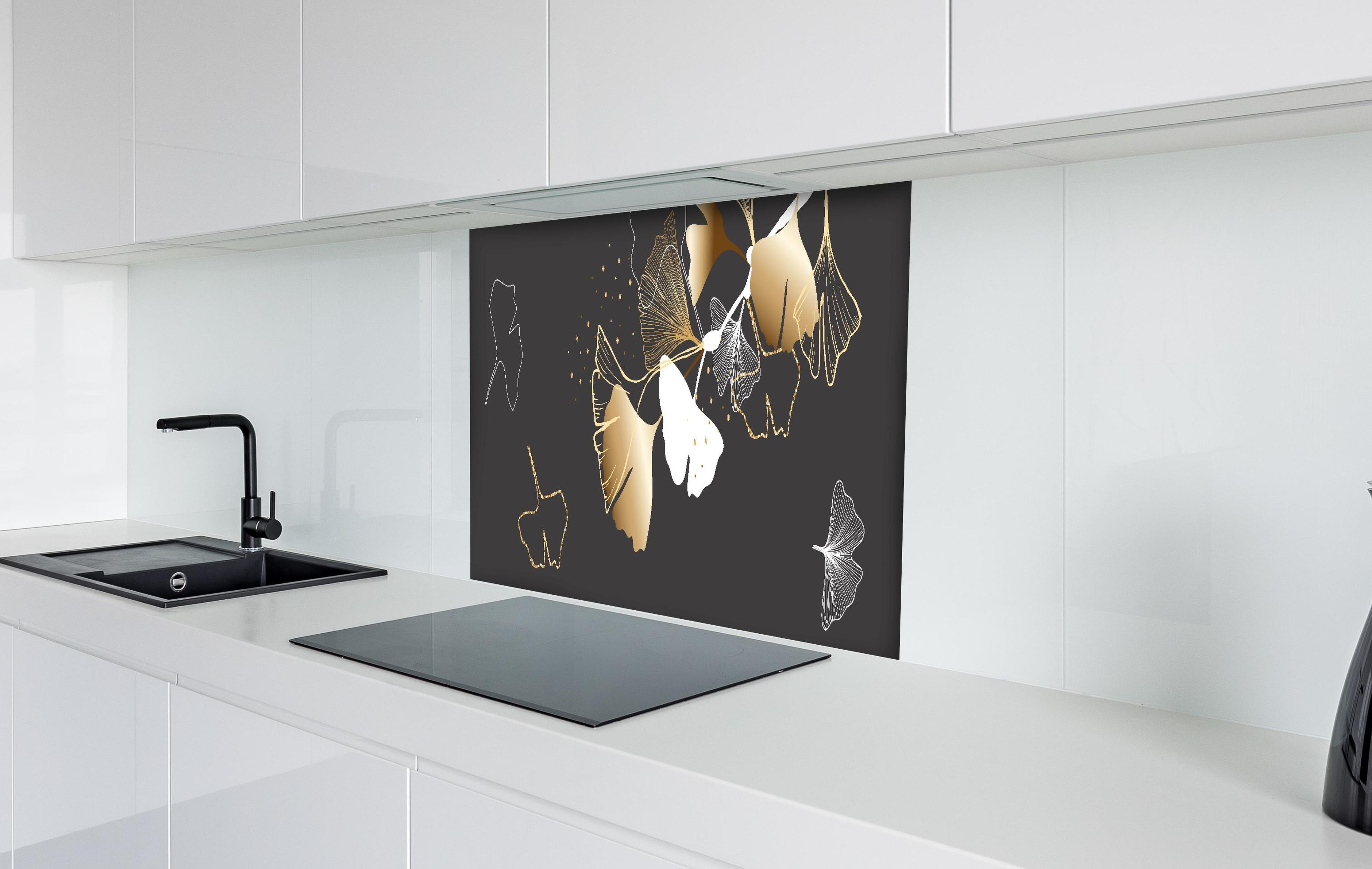 Spritzschutz - Stilisiertes Ginkgo-Design in Gold und Schwarz hinter einem Cerankochfeld zwischen Holz-Kochutensilien