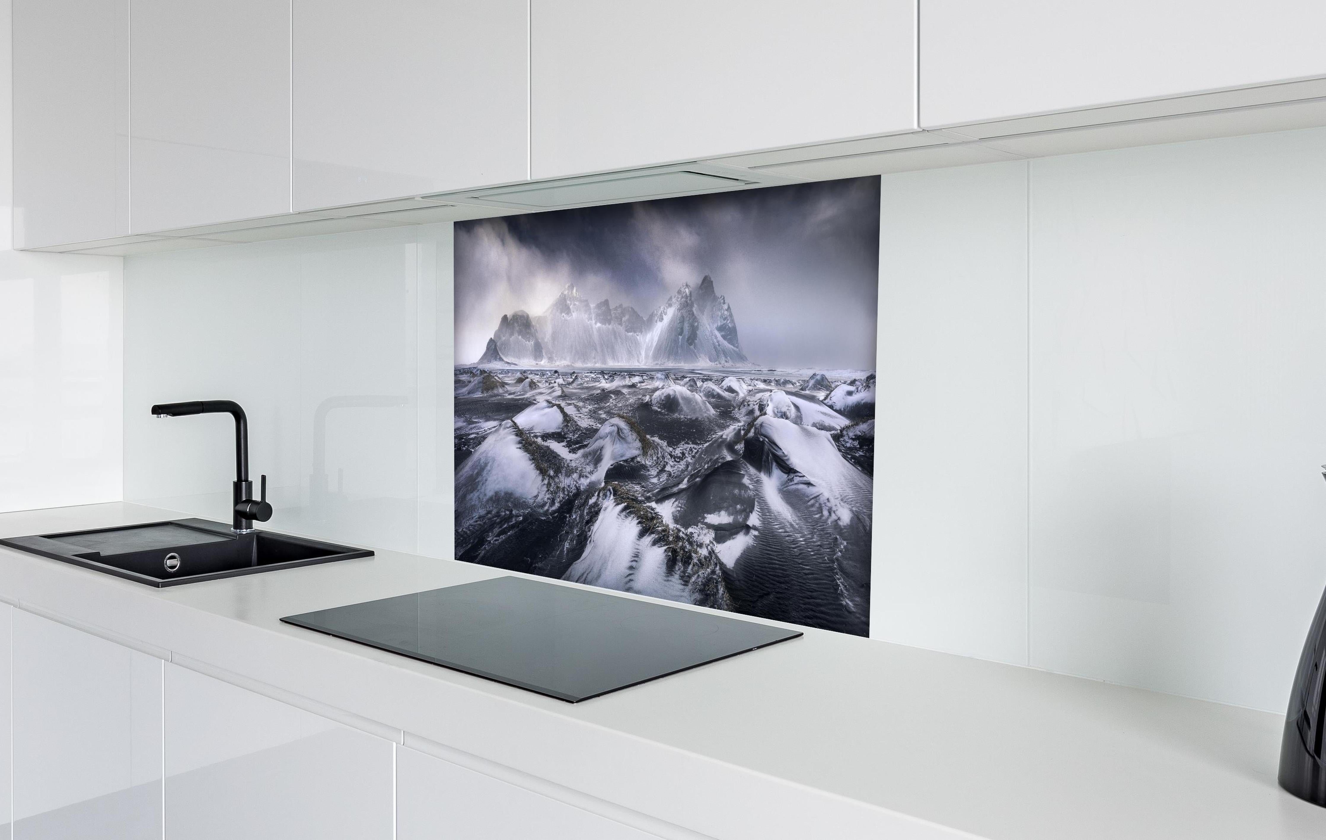 Spritzschutz - Stokksnes Bergkulisse im Schneesturm hinter einem Cerankochfeld zwischen Holz-Kochutensilien