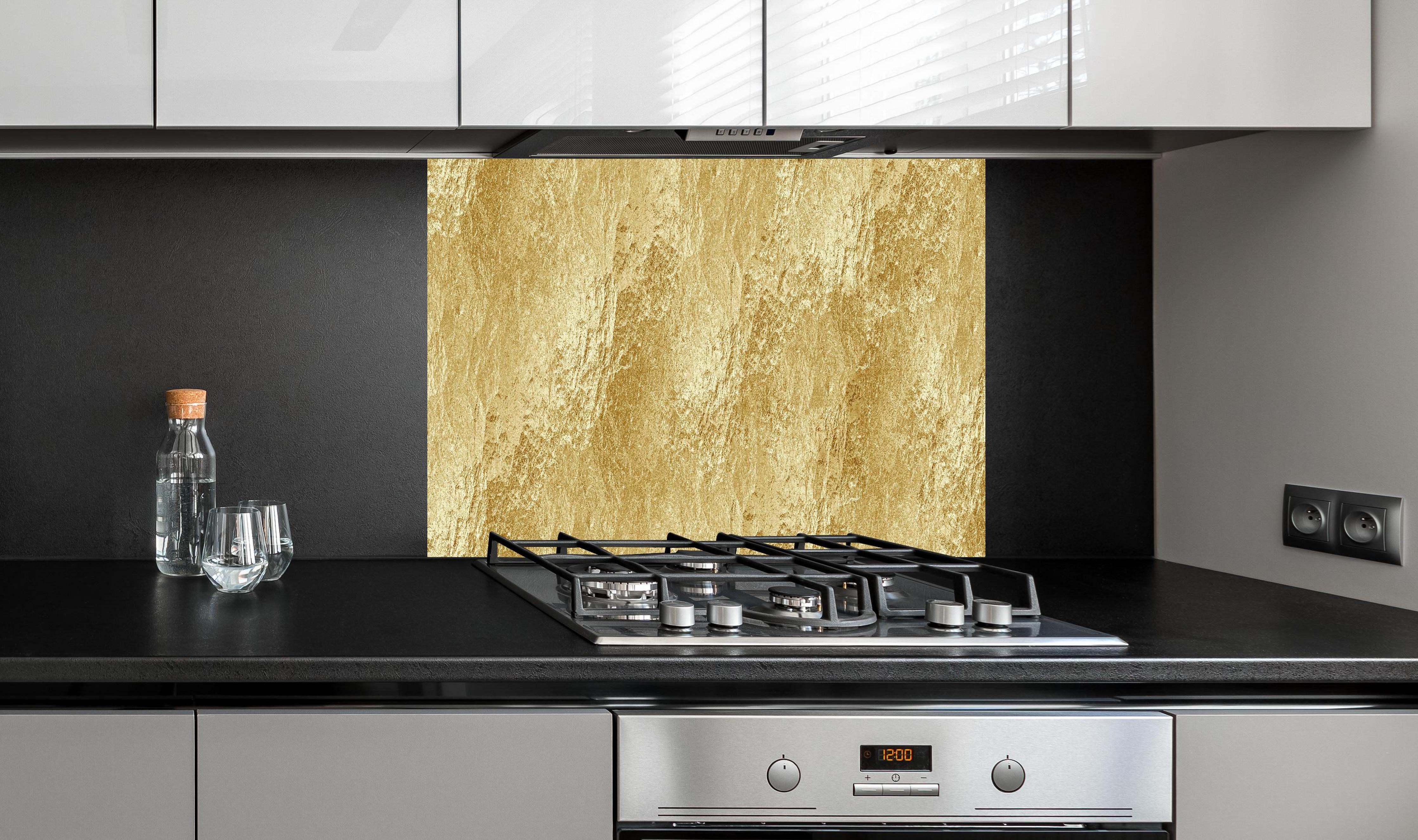 Spritzschutz - Strahlende goldene Luxus Textur hinter einem Cerankochfeld zwischen Holz-Kochutensilien