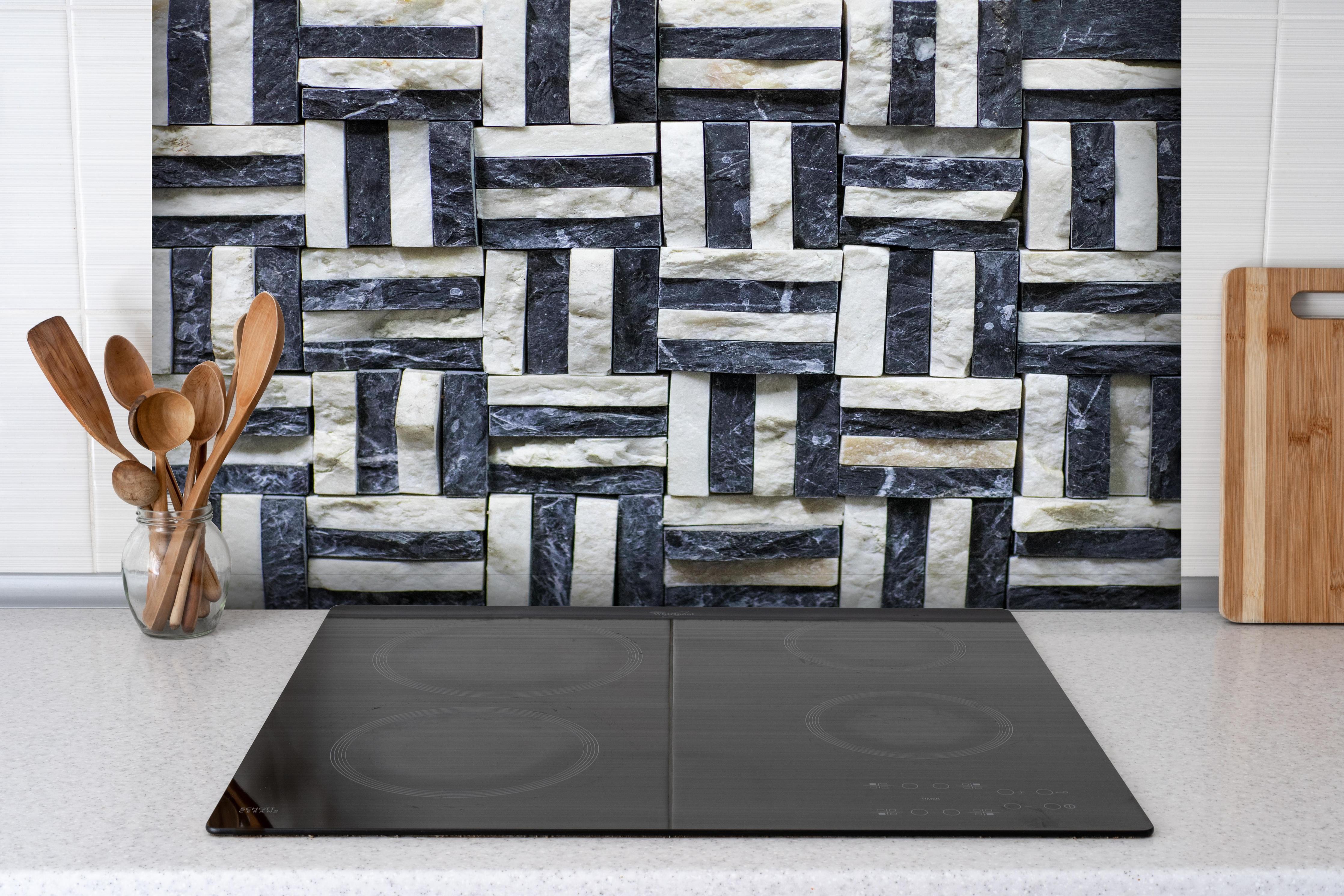 Spritzschutz - Strukturierte Schiefer Wandfliesen in Graunuancen hinter einem Cerankochfeld zwischen Holz-Kochutensilien