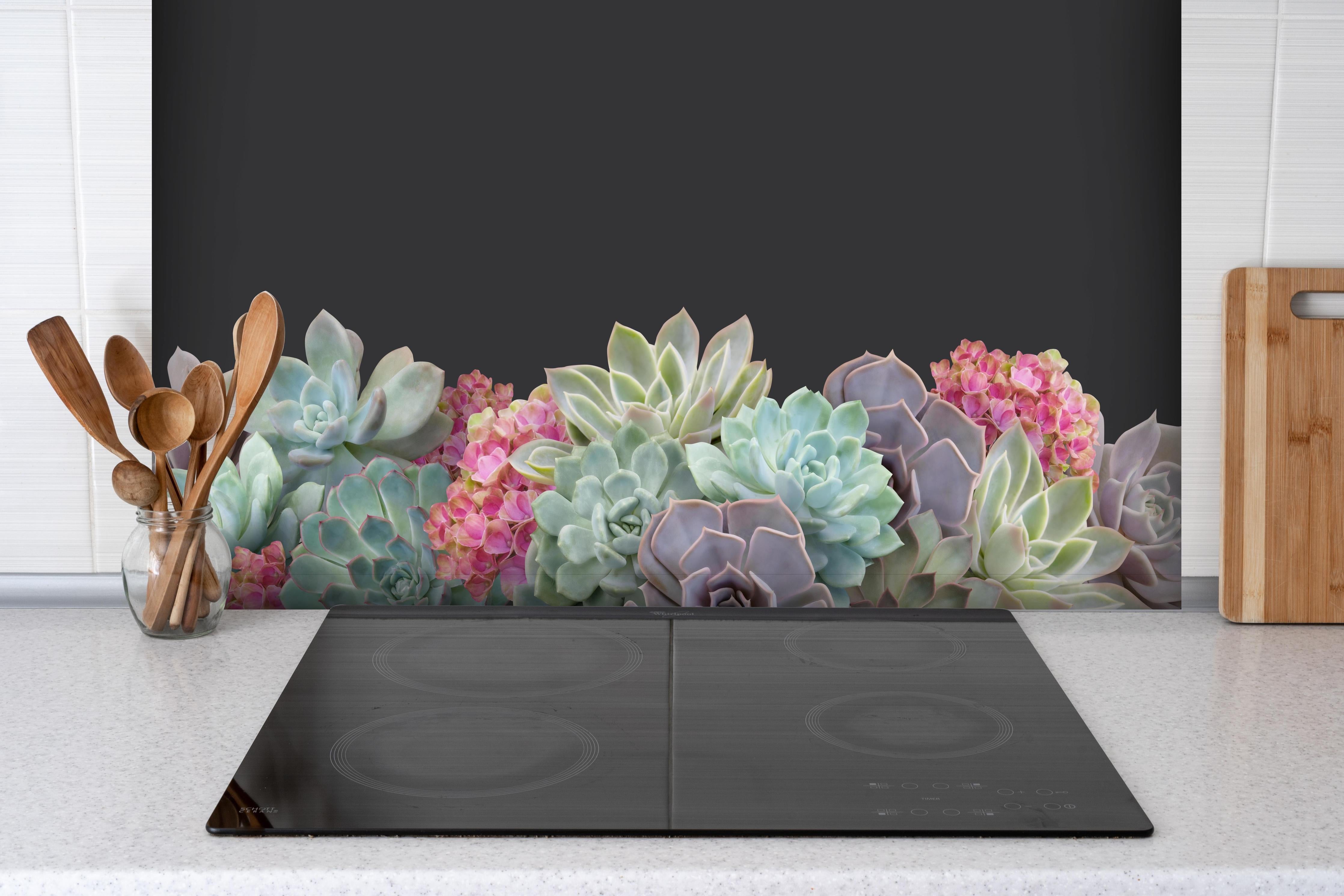 Spritzschutz - Sukkulente Blumen - Bunt hinter einem Cerankochfeld zwischen Holz-Kochutensilien