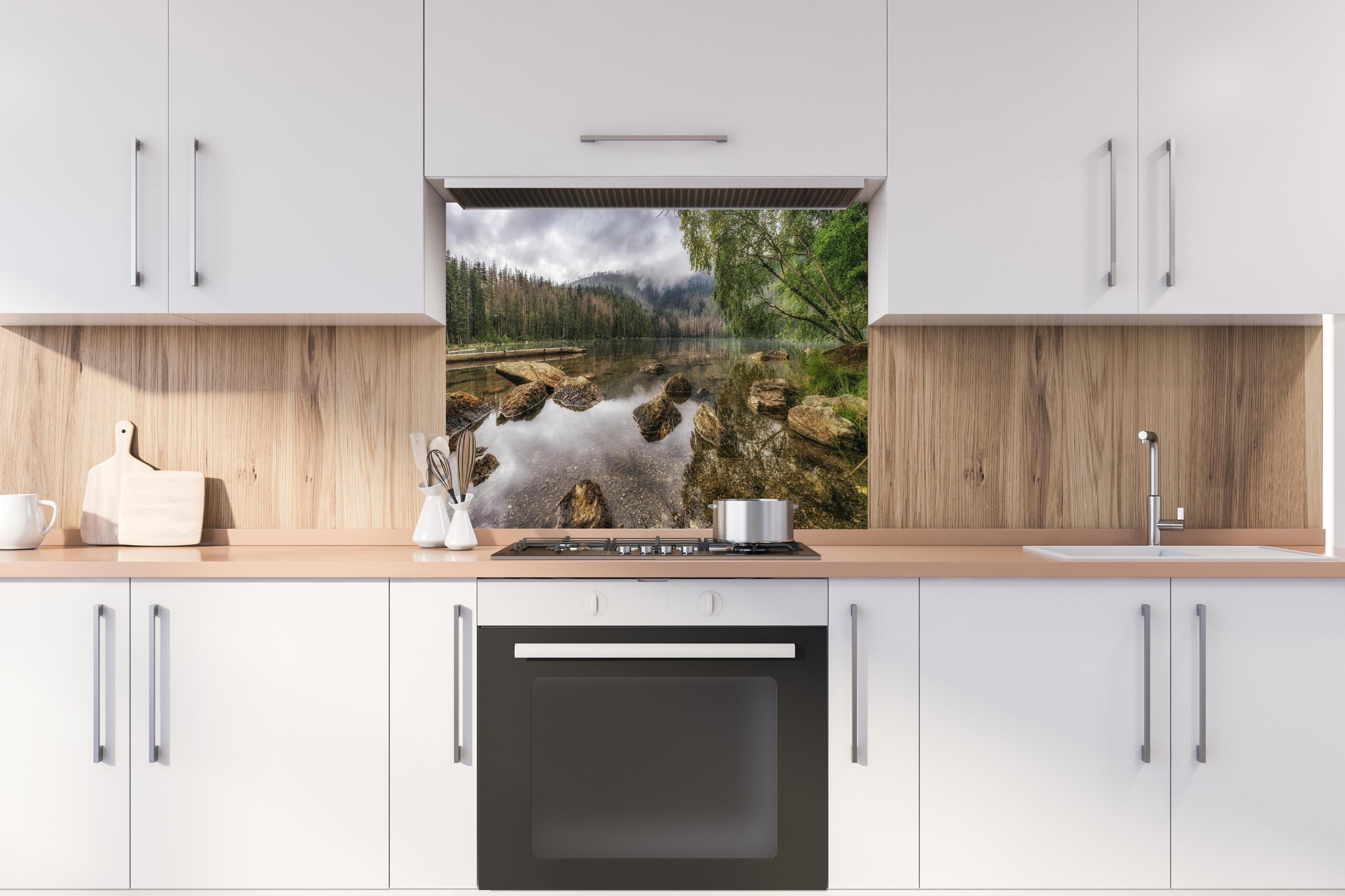 Spritzschutz - Sumava - Schwarzer See - Tschechische Republik hinter einem Cerankochfeld zwischen Holz-Kochutensilien