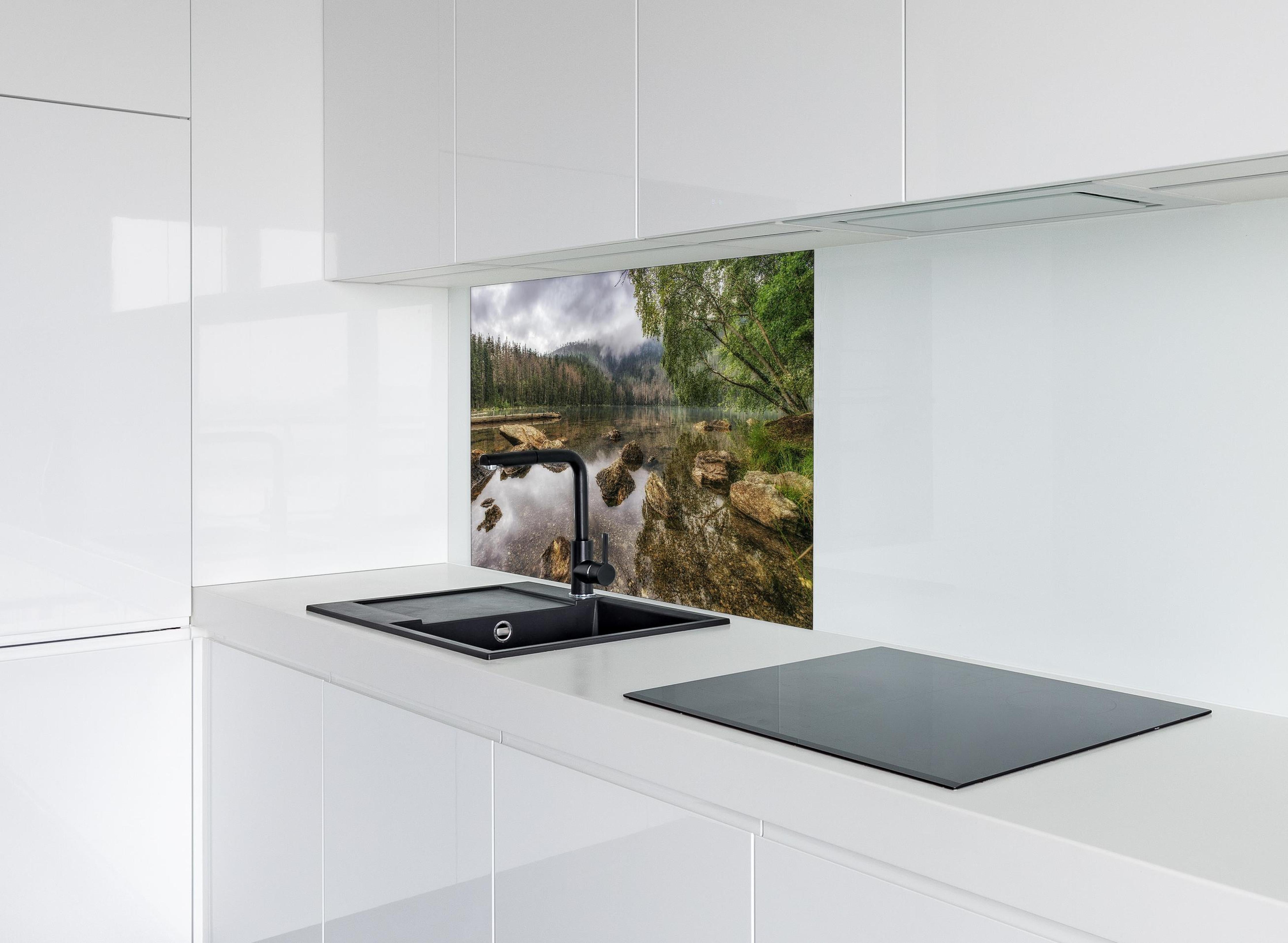 Spritzschutz - Sumava - Schwarzer See - Tschechische Republik hinter einem Cerankochfeld zwischen Holz-Kochutensilien