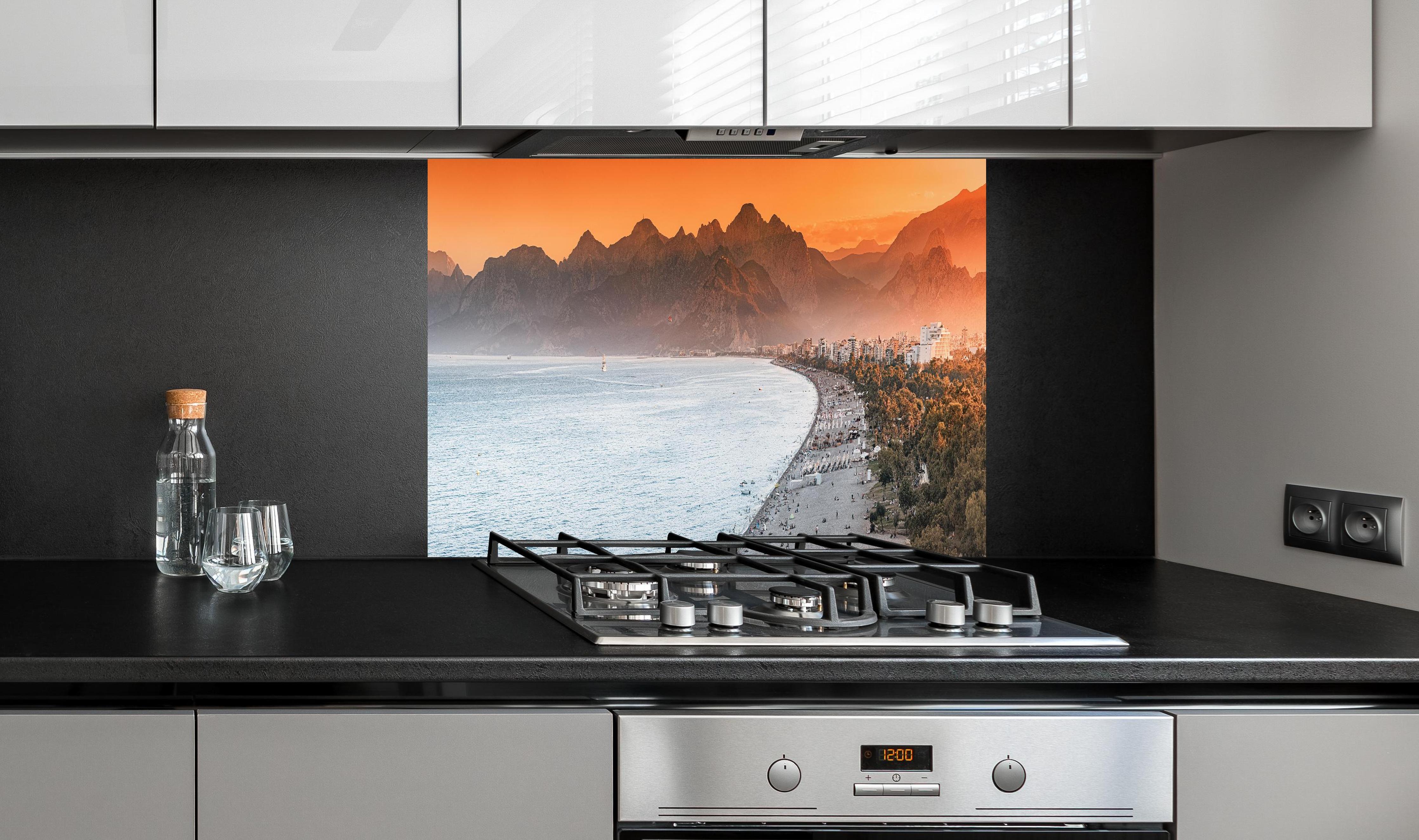 Spritzschutz - Sunset Konyaalti Beach Antalya Türkei hinter einem Cerankochfeld zwischen Holz-Kochutensilien