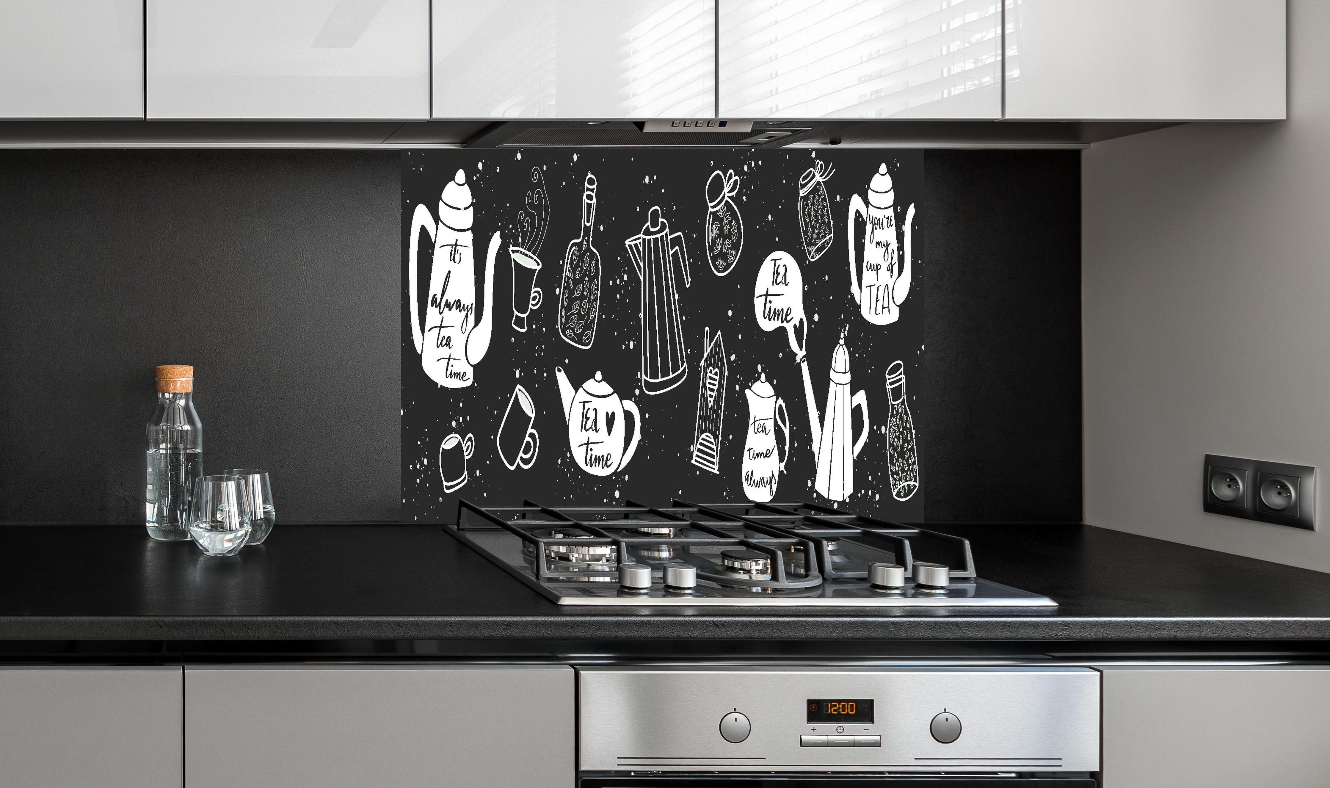 Spritzschutz - Tee Liebhaber Schwarz-Weiß Design Set hinter einem Cerankochfeld zwischen Holz-Kochutensilien