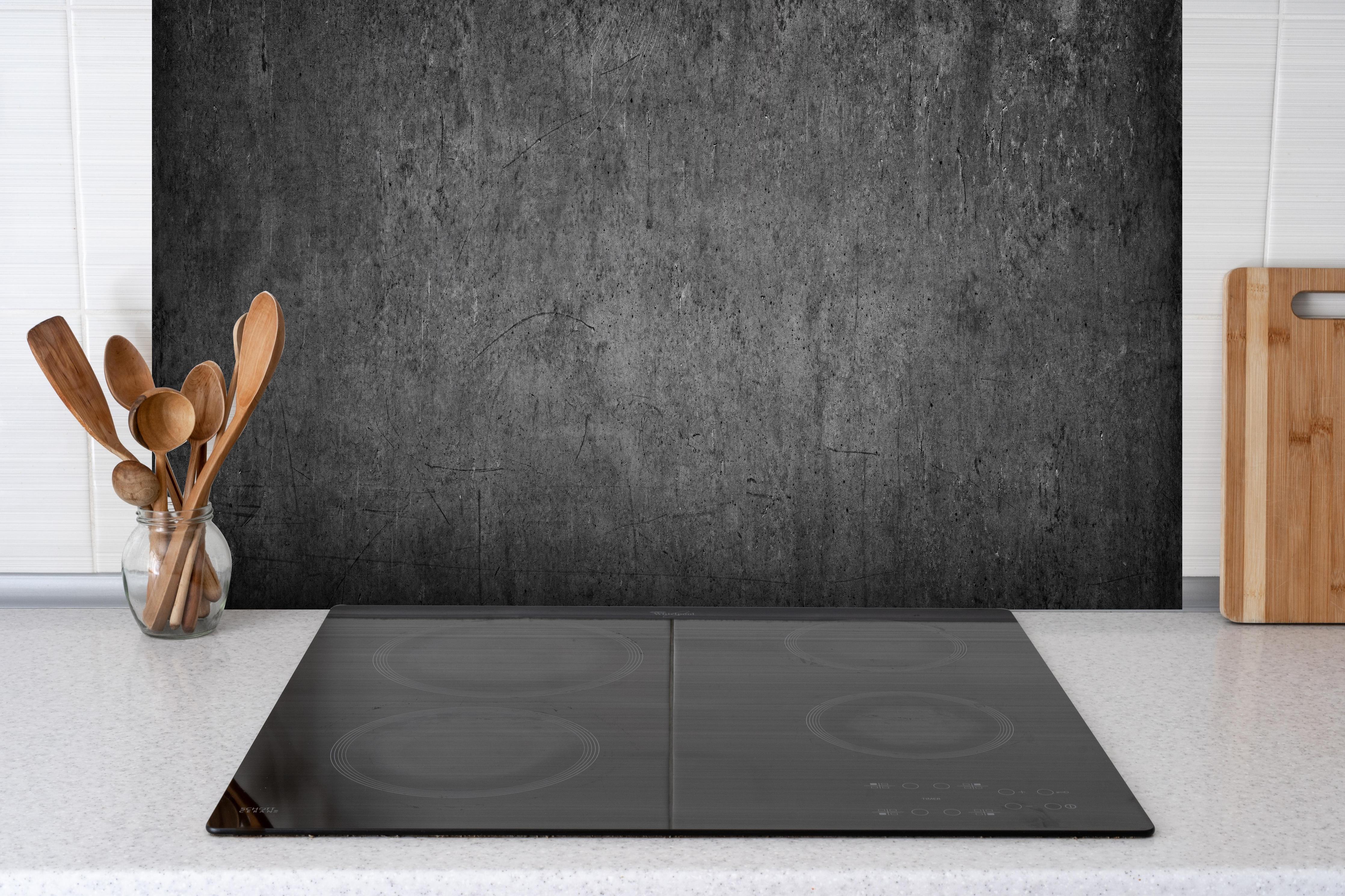 Spritzschutz - Textur Grauer Beton mit Schwarzen Nuancen hinter einem Cerankochfeld zwischen Holz-Kochutensilien