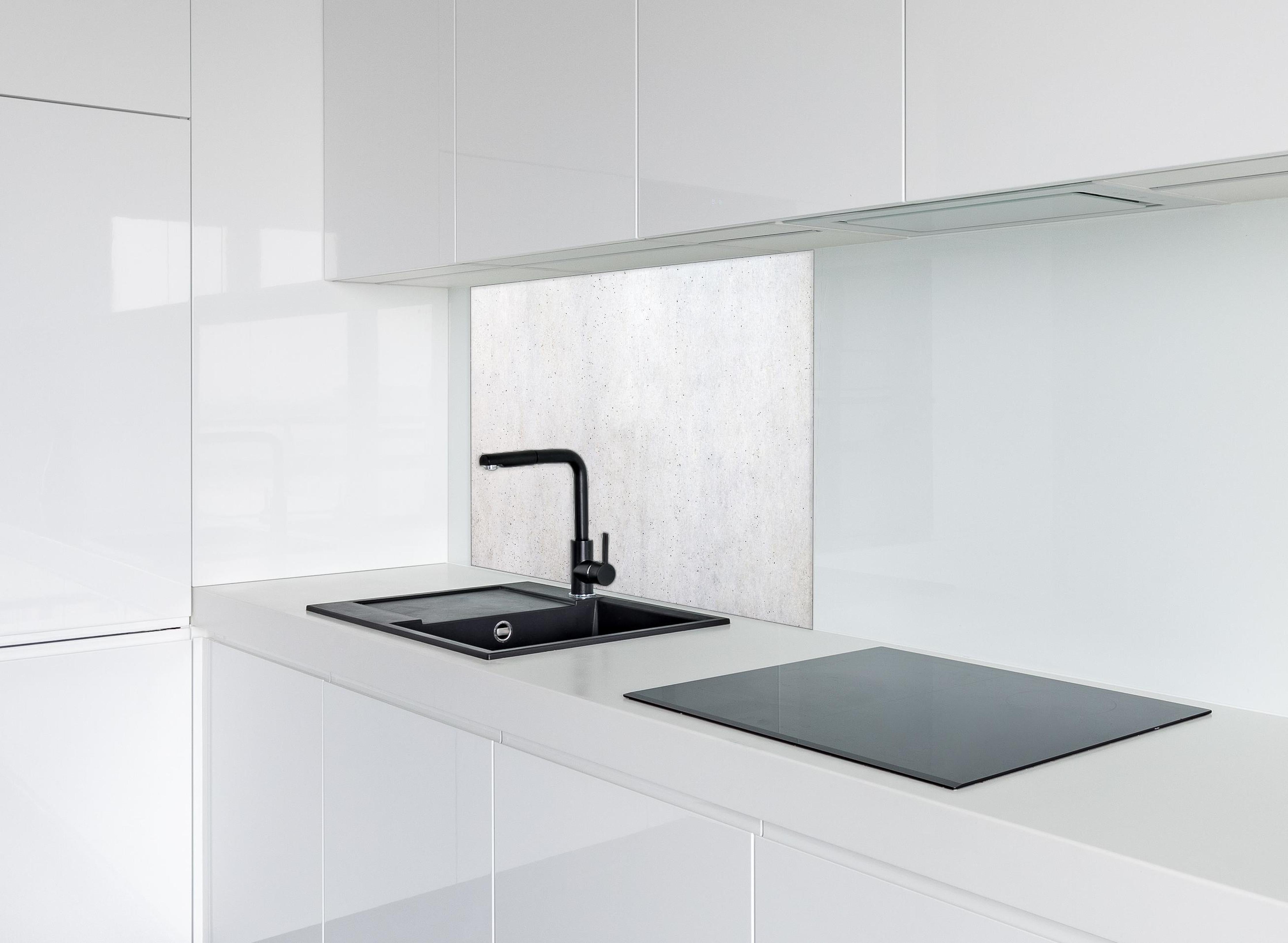 Spritzschutz - Textur einer weißen Betonwand hinter einem Cerankochfeld zwischen Holz-Kochutensilien