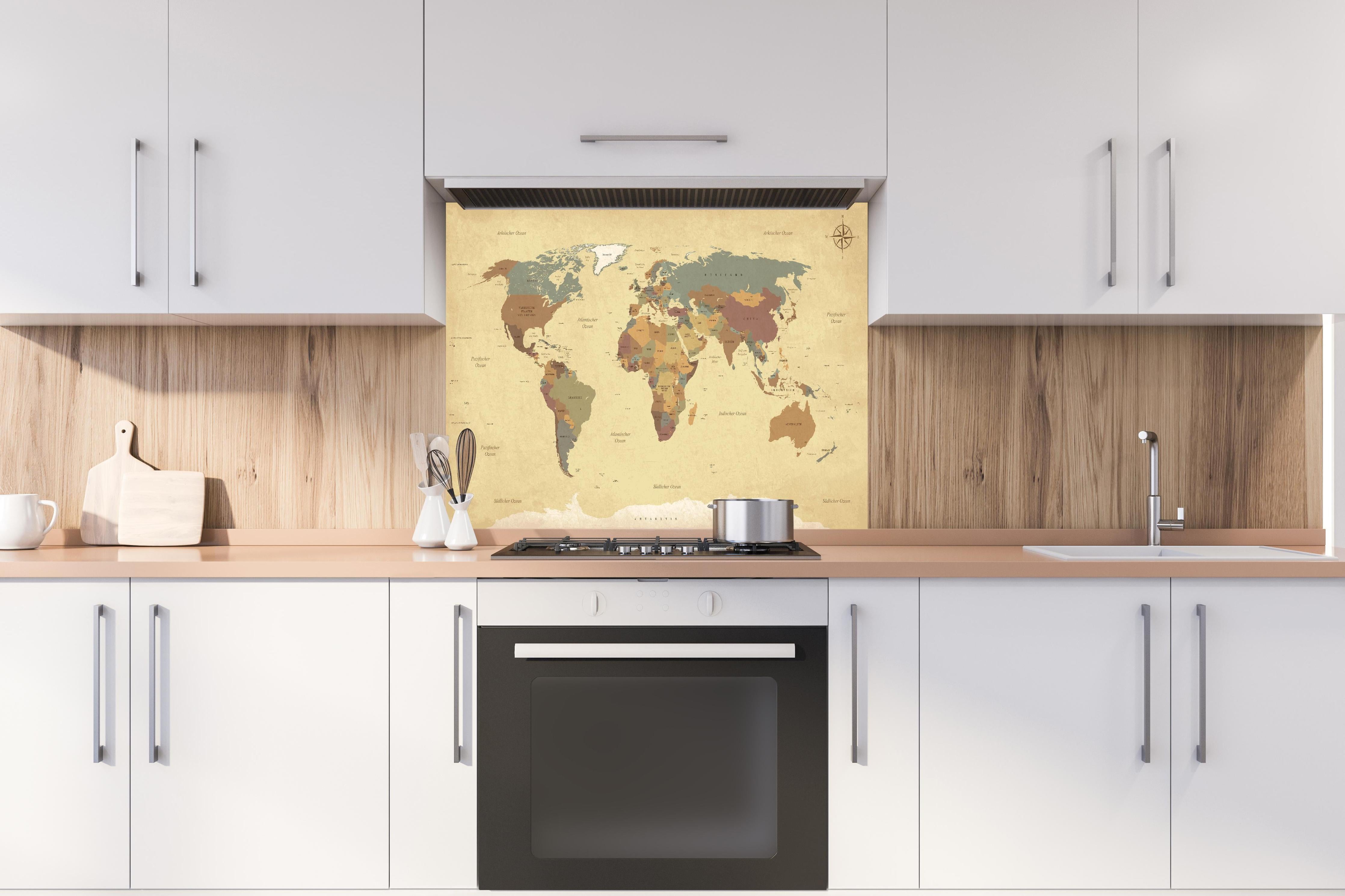 Spritzschutz - Texturierte Vintage Weltkarte in Beigetönen hinter einem Cerankochfeld zwischen Holz-Kochutensilien