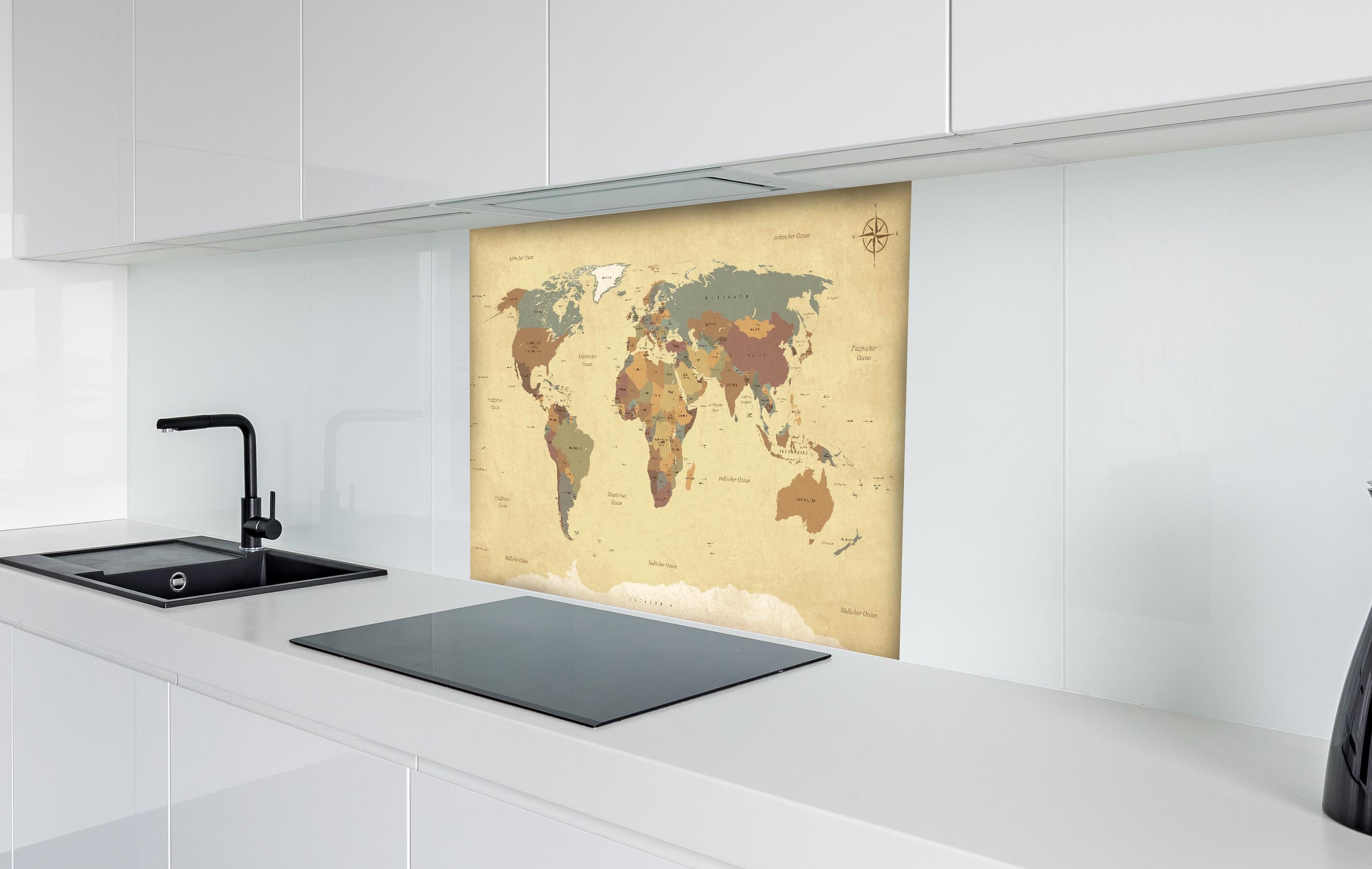 Spritzschutz - Texturierte Vintage Weltkarte in Beigetönen hinter einem Cerankochfeld zwischen Holz-Kochutensilien