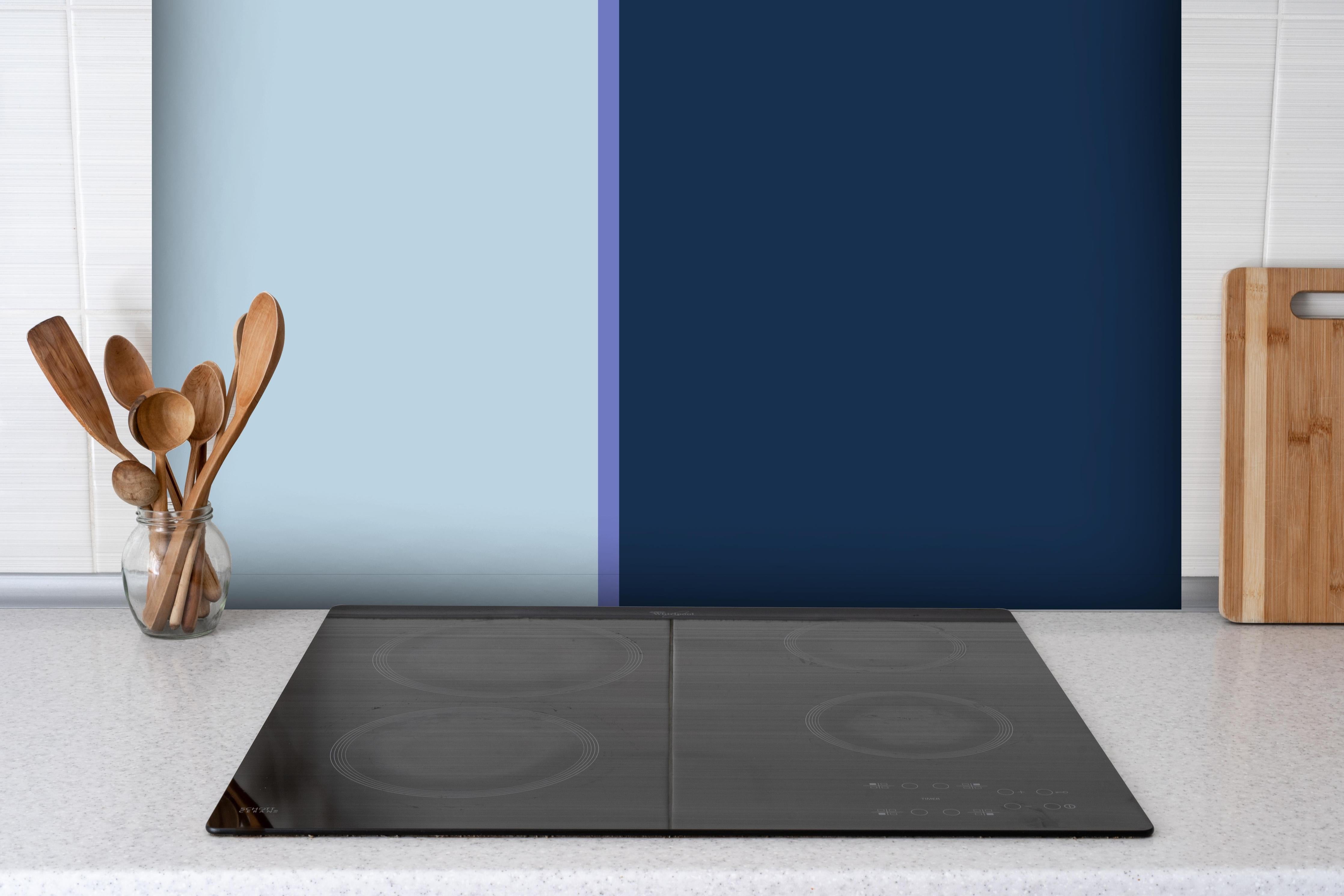 Spritzschutz - The Blues - Easy Vertical - Blueberry hinter einem Cerankochfeld zwischen Holz-Kochutensilien