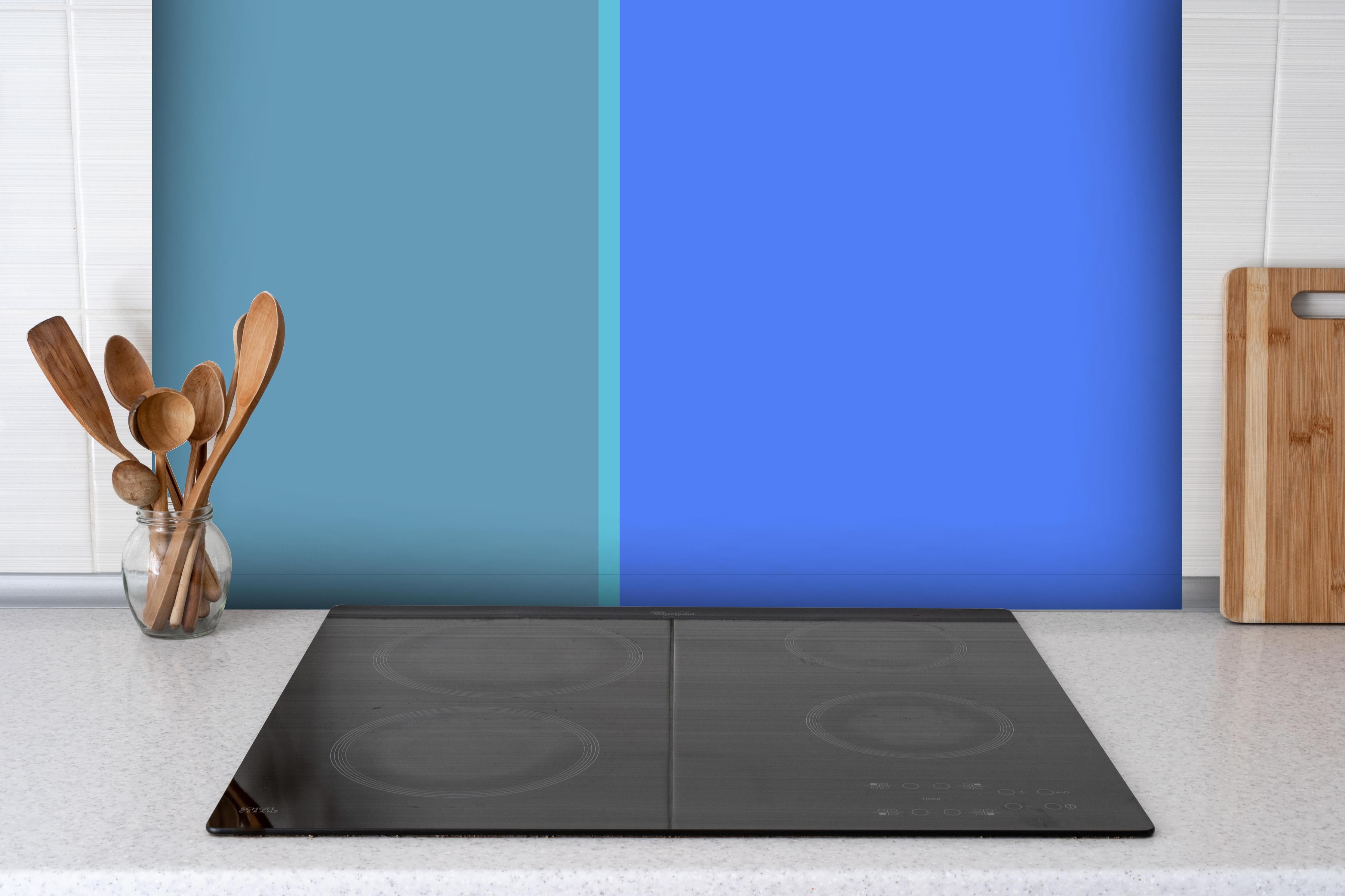 Spritzschutz - The Blues - Easy Vertical - Cornflower hinter einem Cerankochfeld zwischen Holz-Kochutensilien