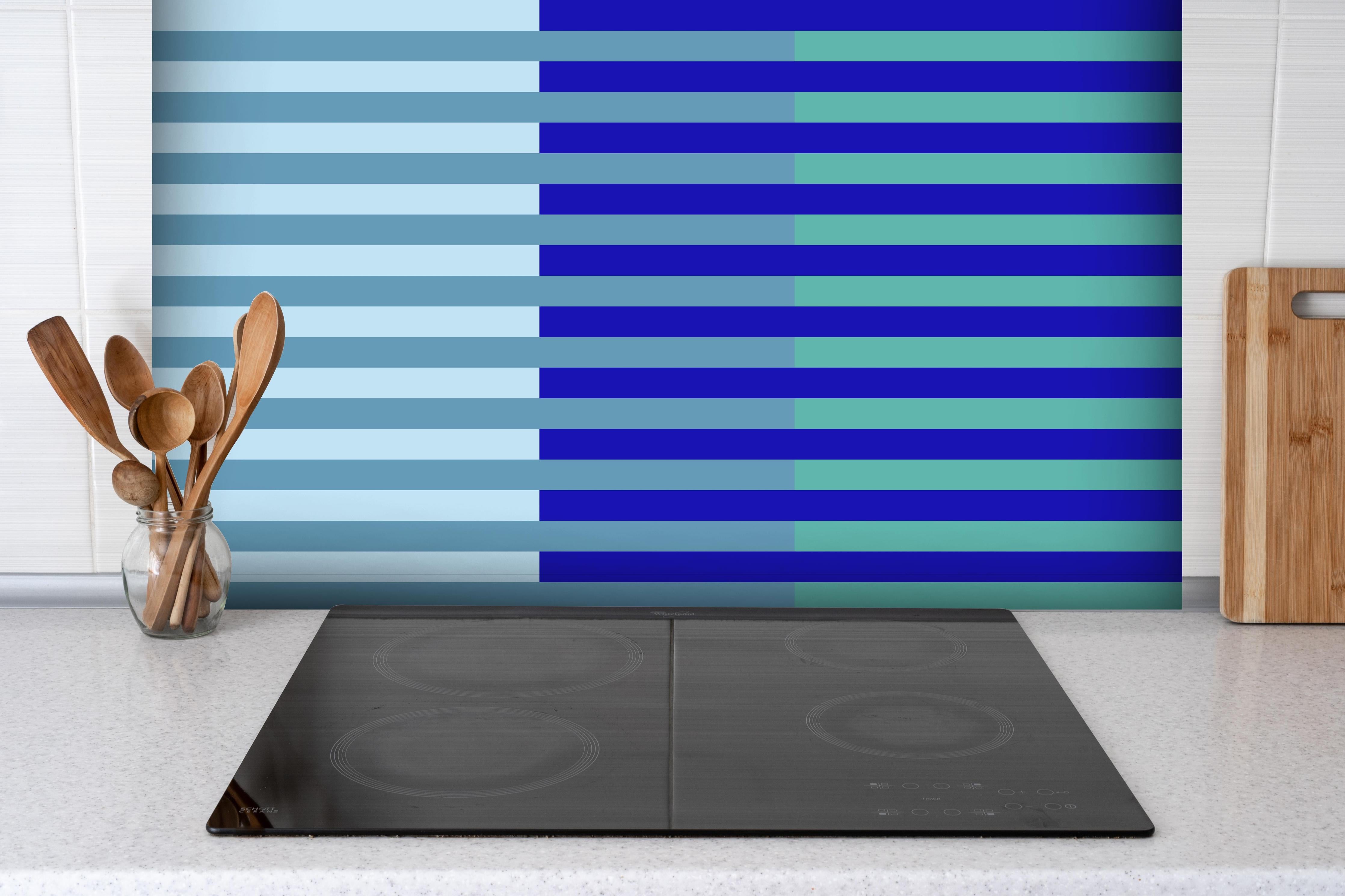 Spritzschutz - The Blues - Multy Stripes - Ocean hinter einem Cerankochfeld zwischen Holz-Kochutensilien