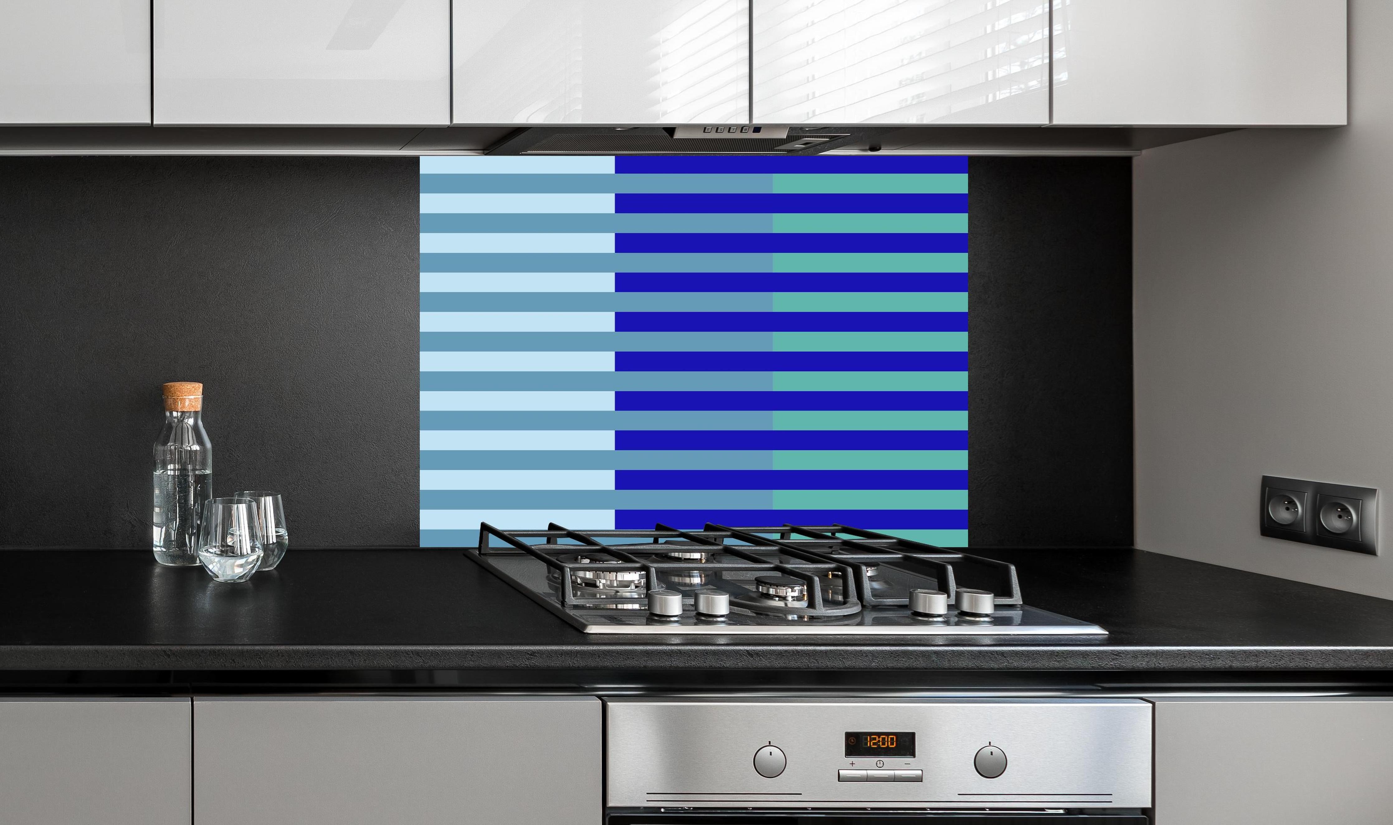 Spritzschutz - The Blues - Multy Stripes - Ocean hinter einem Cerankochfeld zwischen Holz-Kochutensilien