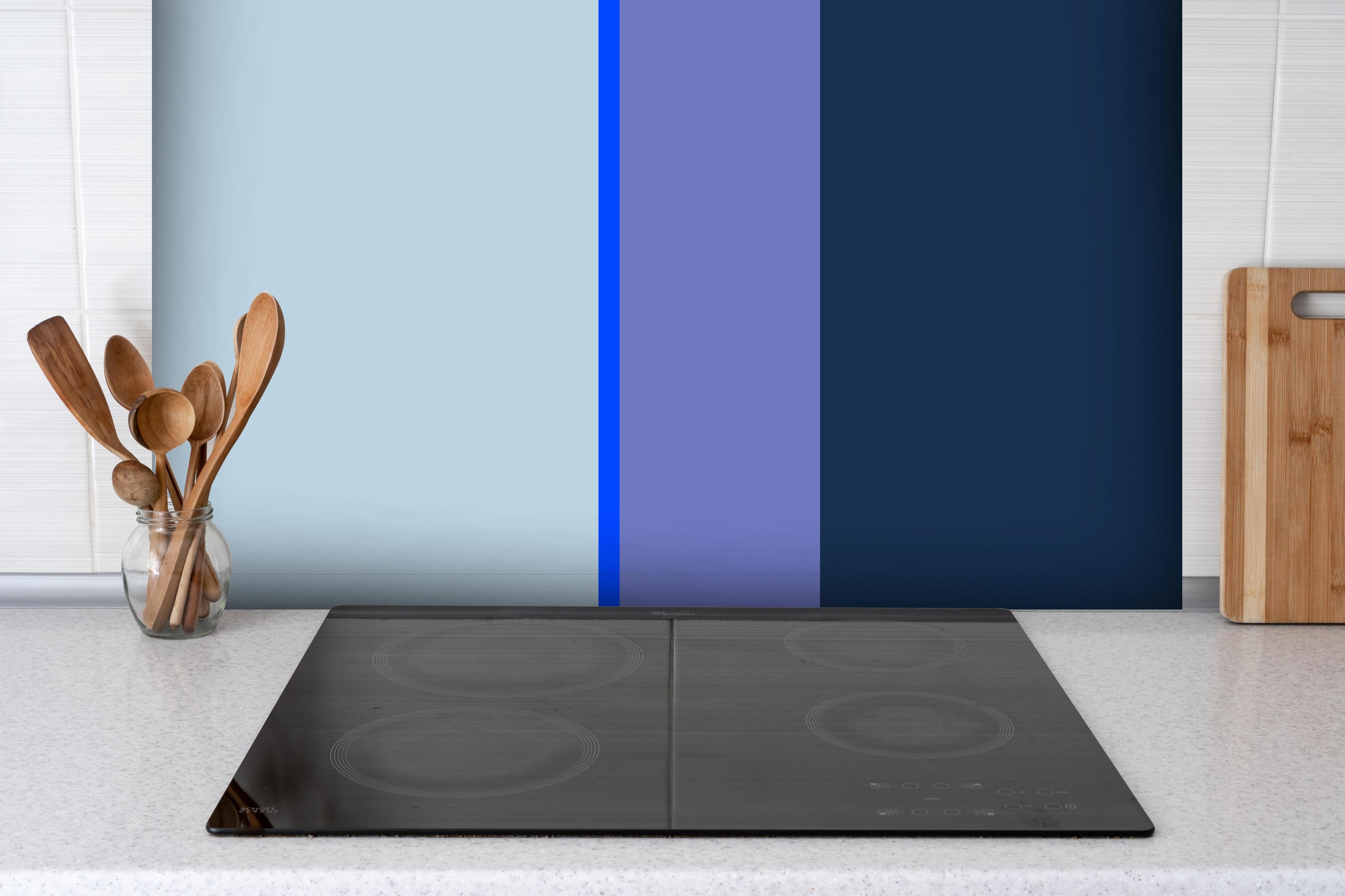 Spritzschutz - The Blues - Vertical - Blueberry hinter einem Cerankochfeld zwischen Holz-Kochutensilien