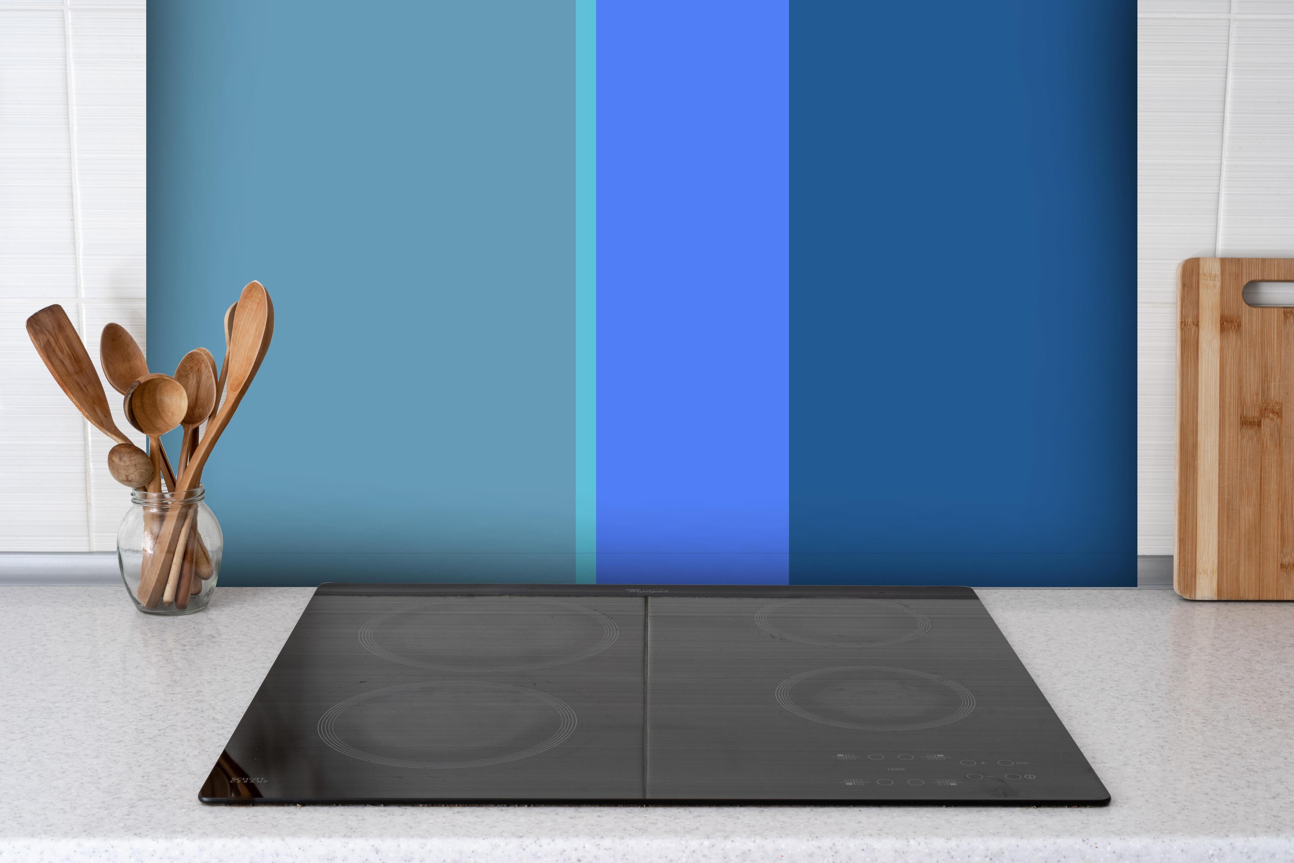 Spritzschutz - The Blues - Vertical - Cornflower hinter einem Cerankochfeld zwischen Holz-Kochutensilien