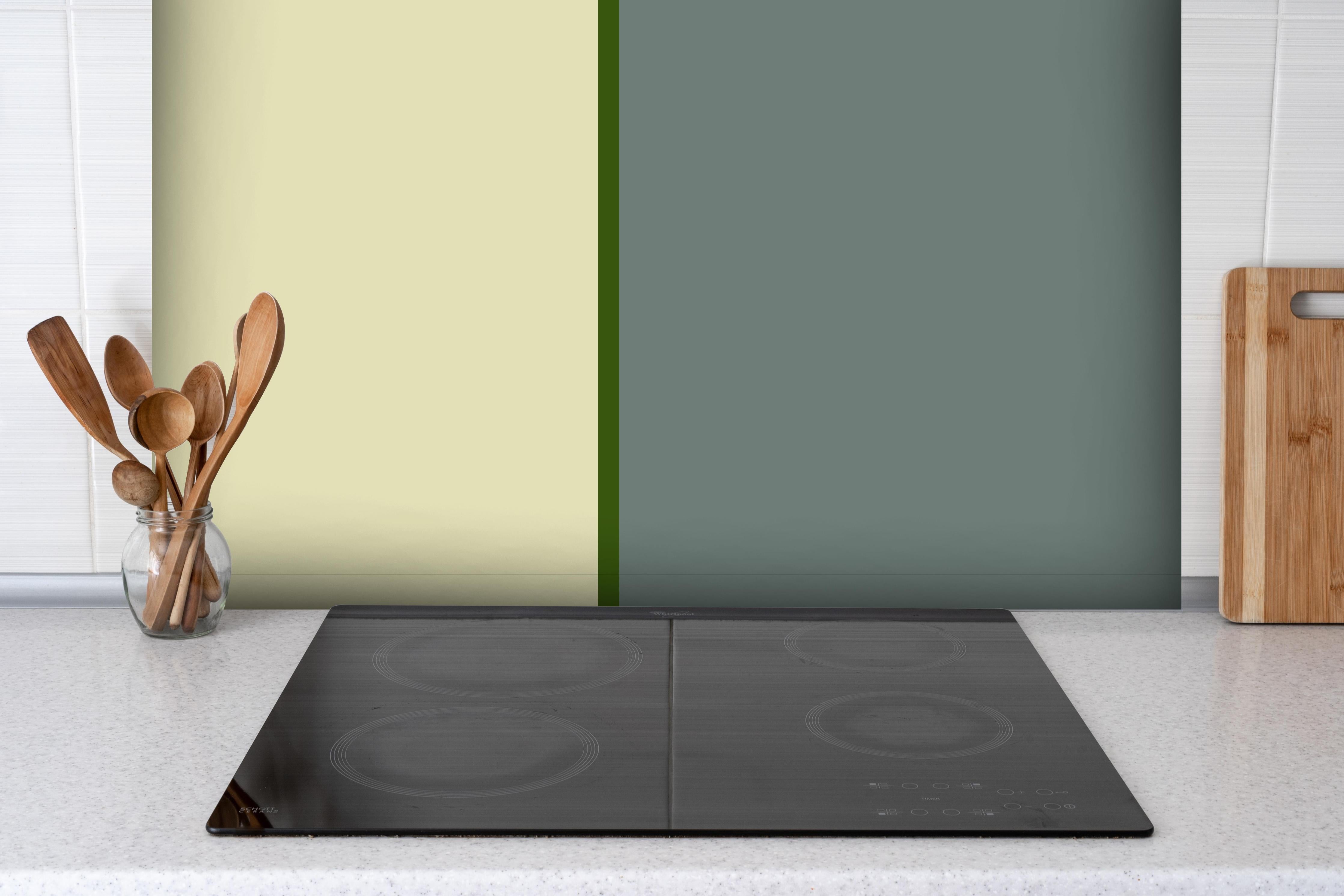 Spritzschutz - The Greens - Easy Vertical - Avocado hinter einem Cerankochfeld zwischen Holz-Kochutensilien