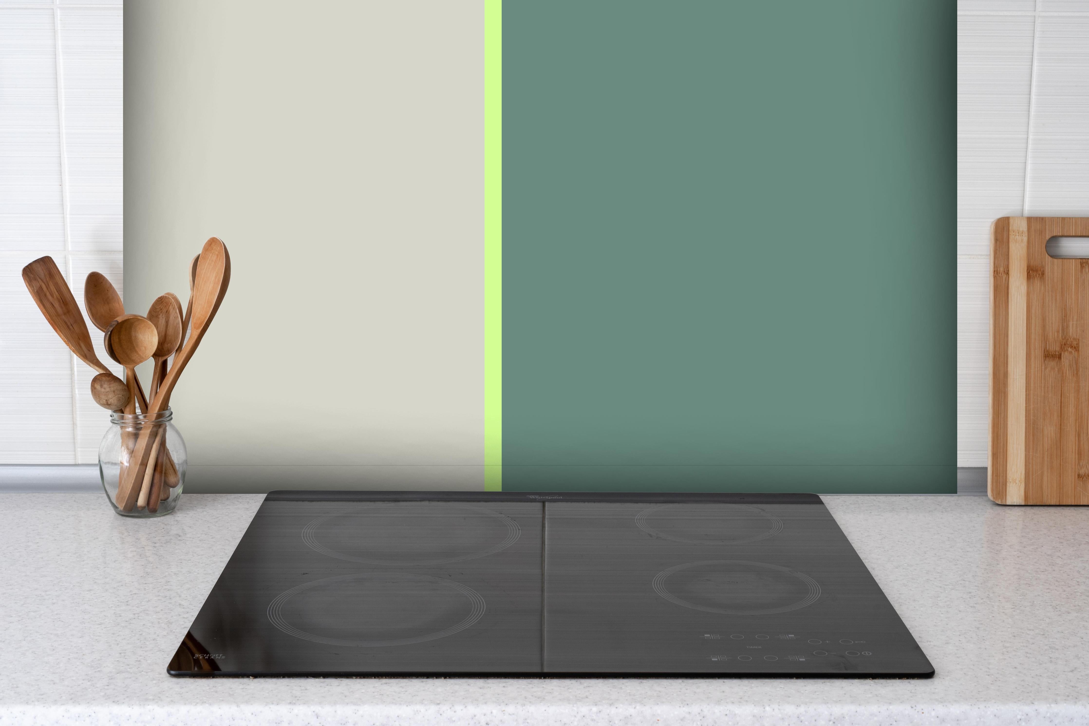 Spritzschutz - The Greens - Easy Vertical - Granny Smith hinter einem Cerankochfeld zwischen Holz-Kochutensilien