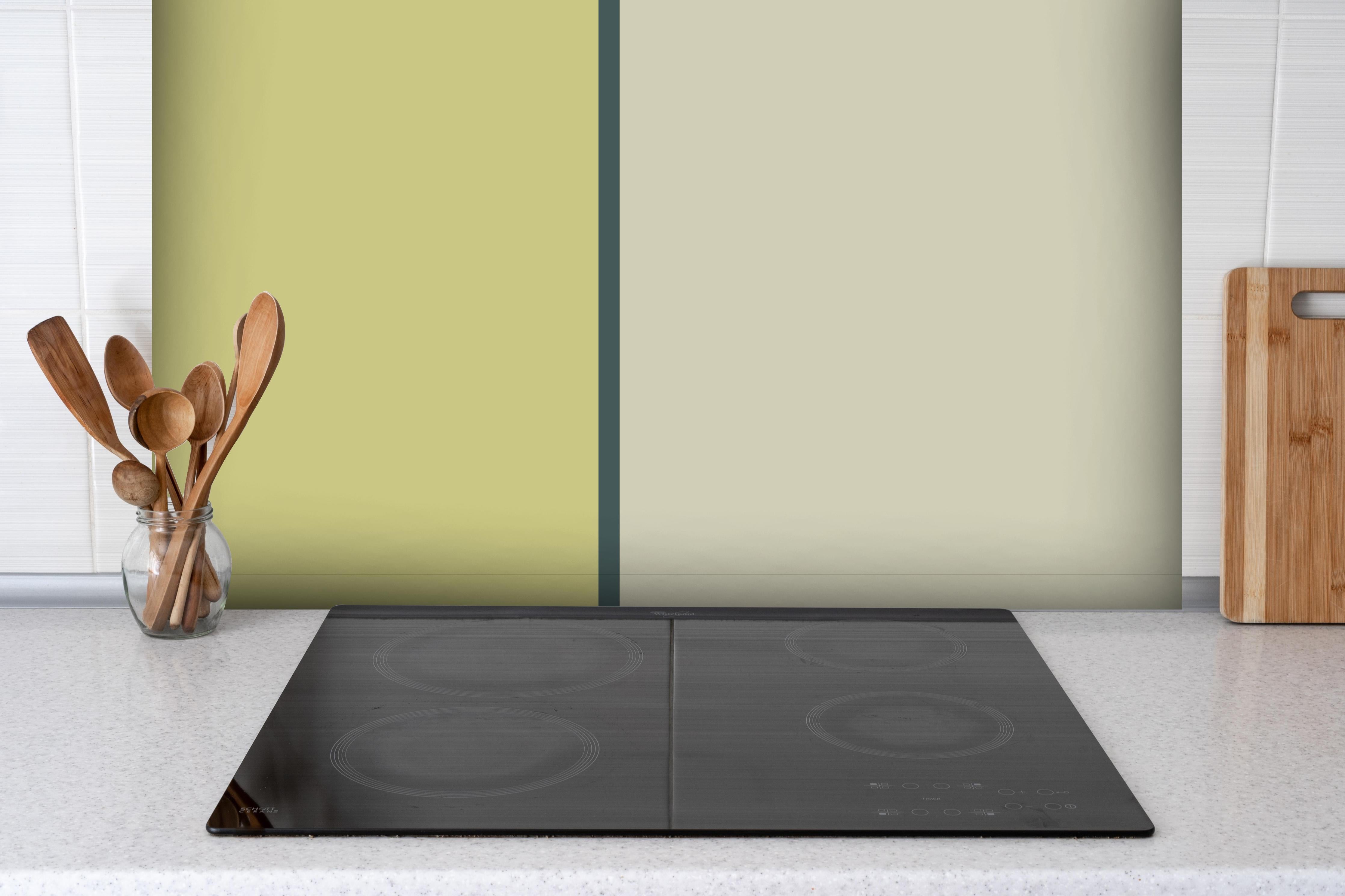 Spritzschutz - The Greens - Easy Vertical - Pistachio hinter einem Cerankochfeld zwischen Holz-Kochutensilien
