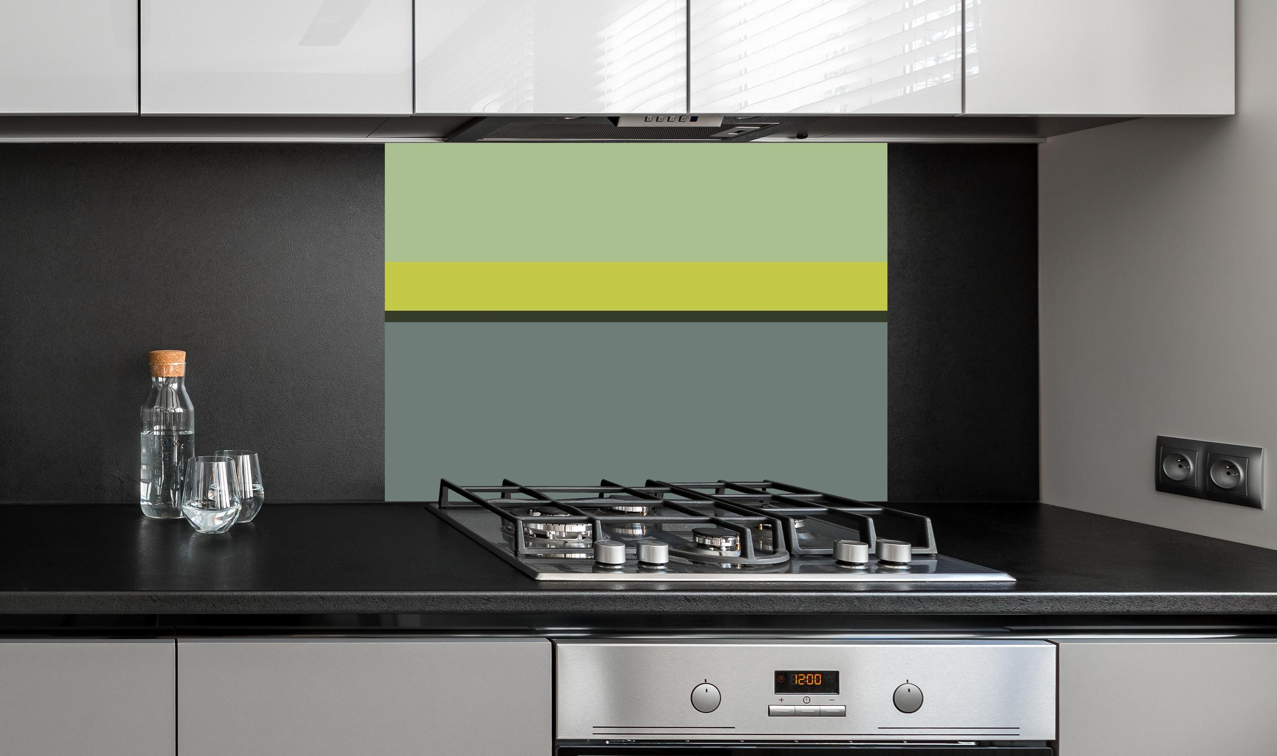 Spritzschutz - The Greens - Horizontal - Matcha hinter einem Cerankochfeld zwischen Holz-Kochutensilien
