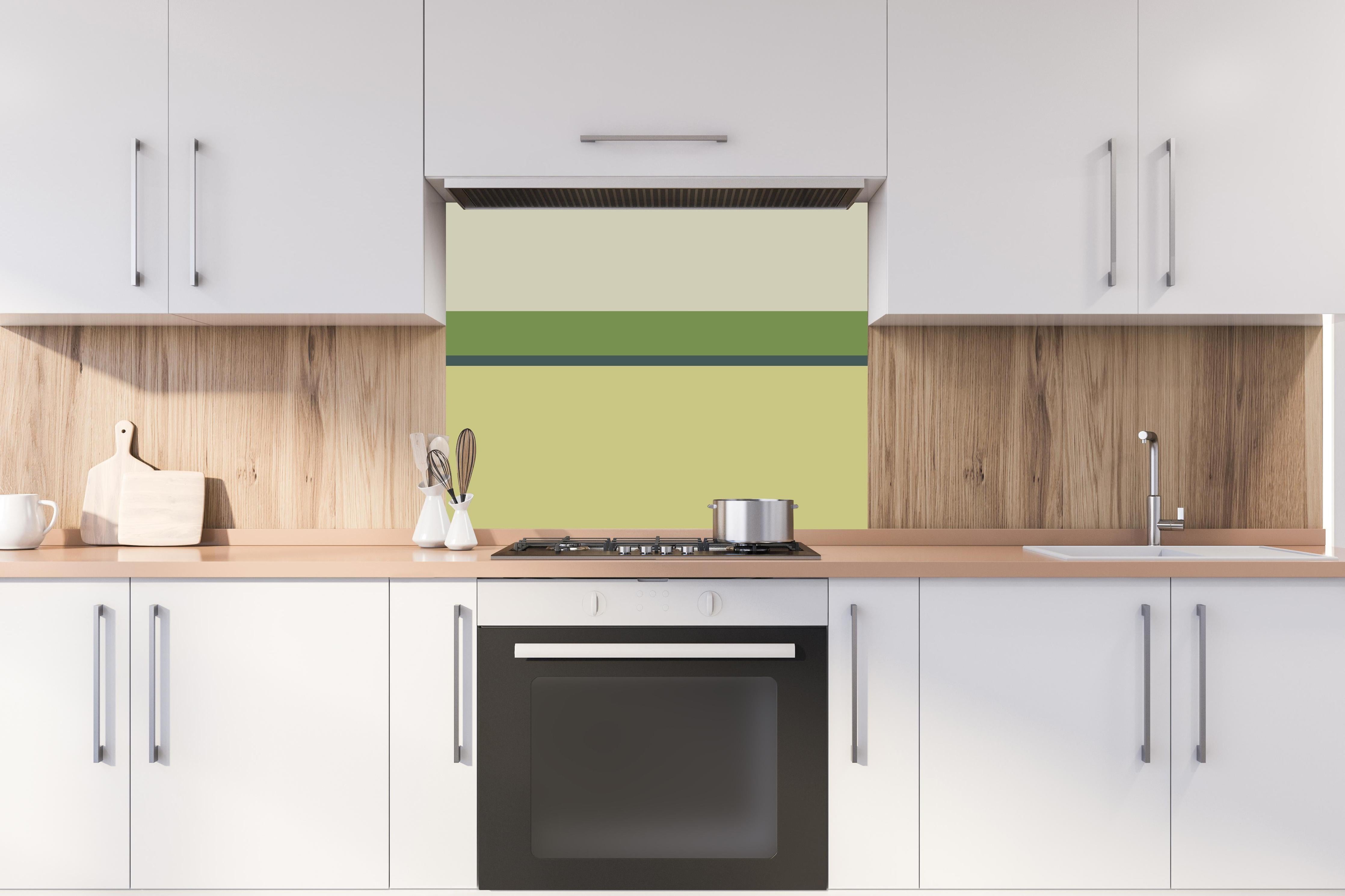 Spritzschutz - The Greens - Horizontal - Pistachio hinter einem Cerankochfeld zwischen Holz-Kochutensilien